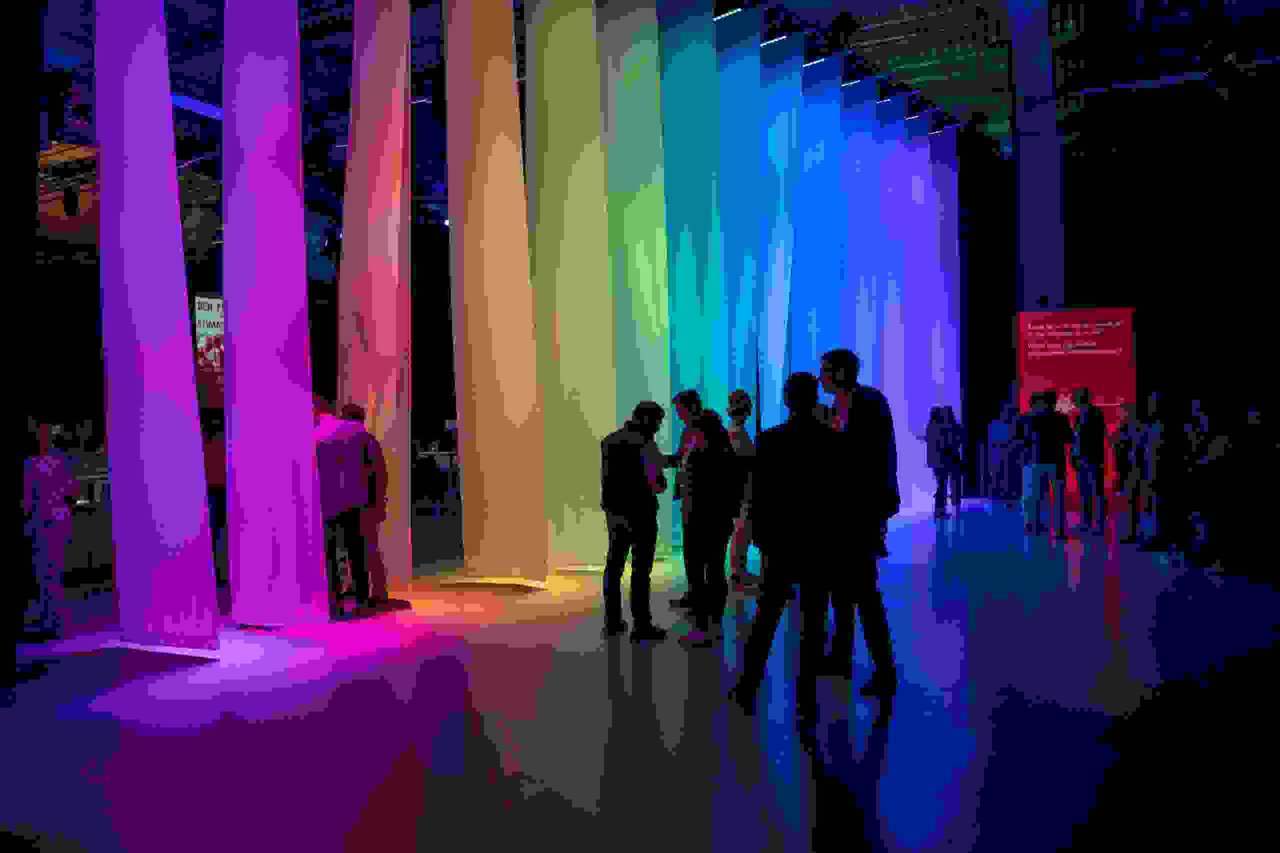 Besuchende flanieren durch bunt beleuchtete Stoffbahnen bei einem kreativen Corporate Event von Mobiliar, organisiert von evenjo. Mobiliar Event, Corporate Event, Lichtinszenierung, Brand Experience, Eventdesign, Farbinszenierung, Networking Event, live kommunikation, Corporate-Event, Eventagentur bern, eventplanung, firmenevents, teamevents bern, jubiläumsfeier, networking anlass, mitarbeiter:innenanlass