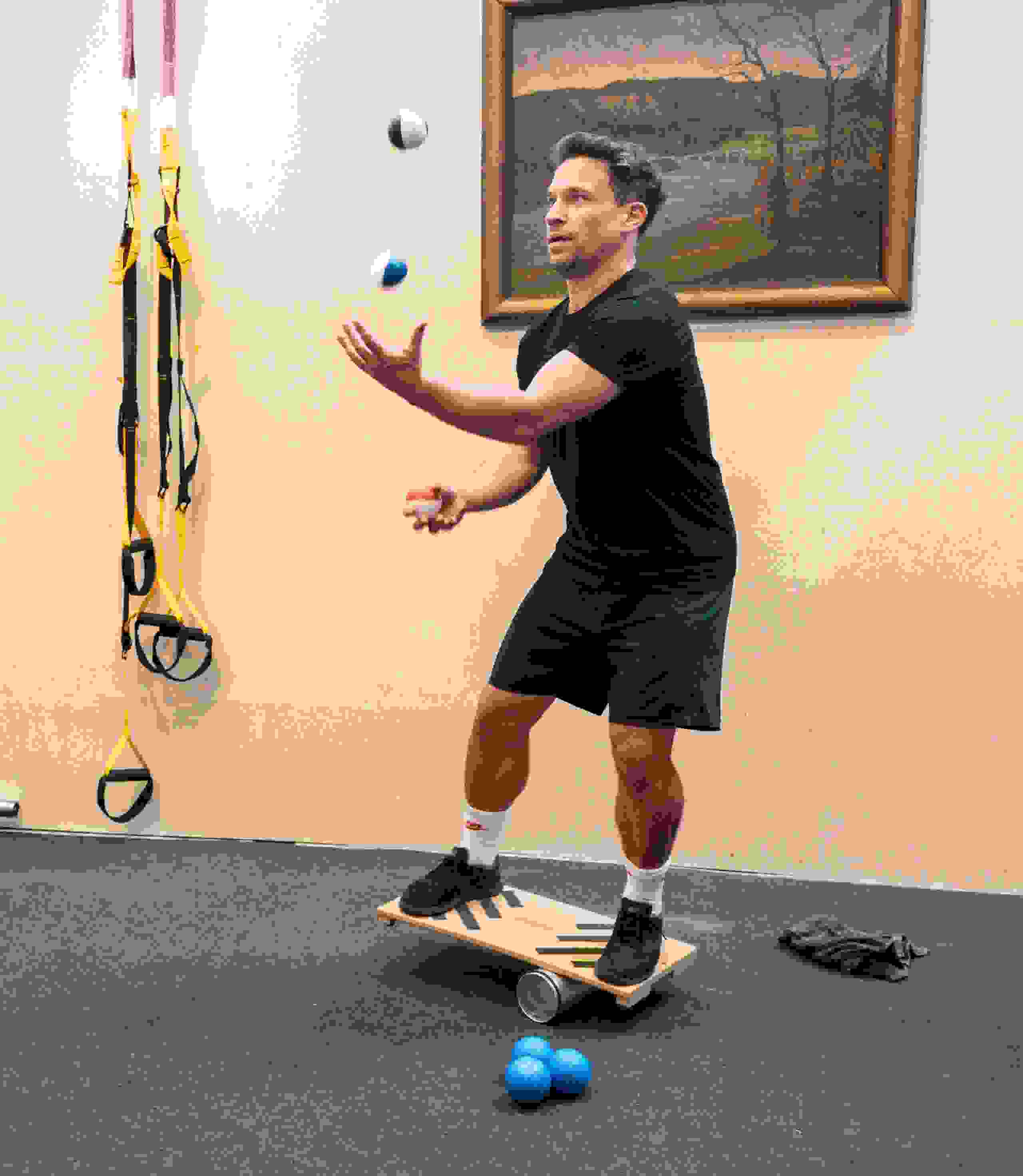 Daniel Schmutz  jongliert auf Balance-Board während Fitness-Session bei evenjo im Gym. Koordination, Geschicklichkeit, Teambuilding, Sport, Teamwork, Bewegung, Gesundheitsförderung, Eventplanung, Live-Kommunikation, Brand Experience, Markenerlebnis, Eventagentur Bern, Unik