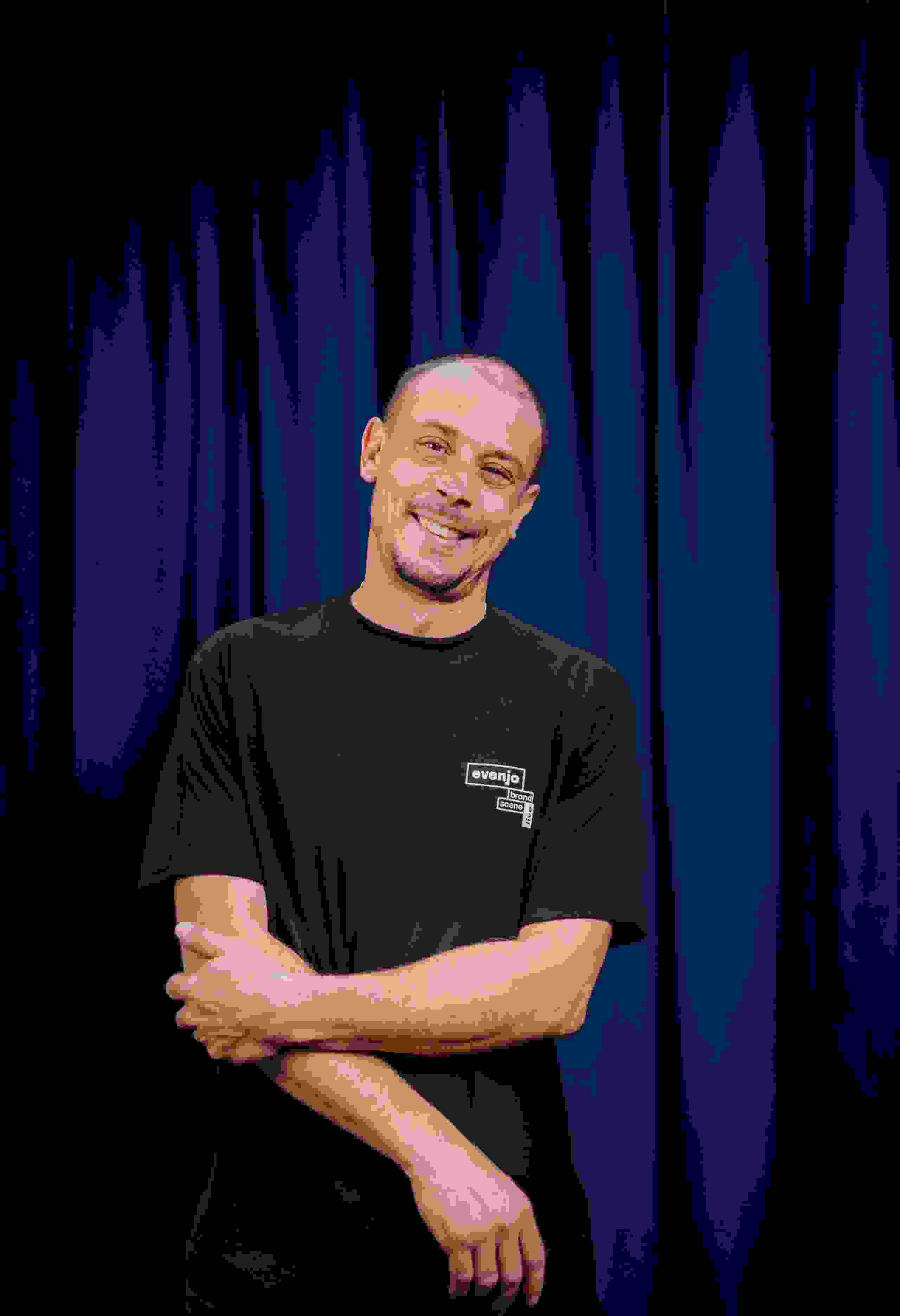 Mitarbeiter Basil Walther der Live Kommunikations Agentur evenjo mit schwarzem T-Shirt vor blauem Hintergrund, Porträt für Teamvorstellung, live kommunikation, Corporate-Event, Eventagentur bern, eventplanung, firmenevents, teamevents bern, jubiläumsfeier, networking anlass, mitarbeiteranlass, Dekoration, Polydesigner 3D, evenjo-Team