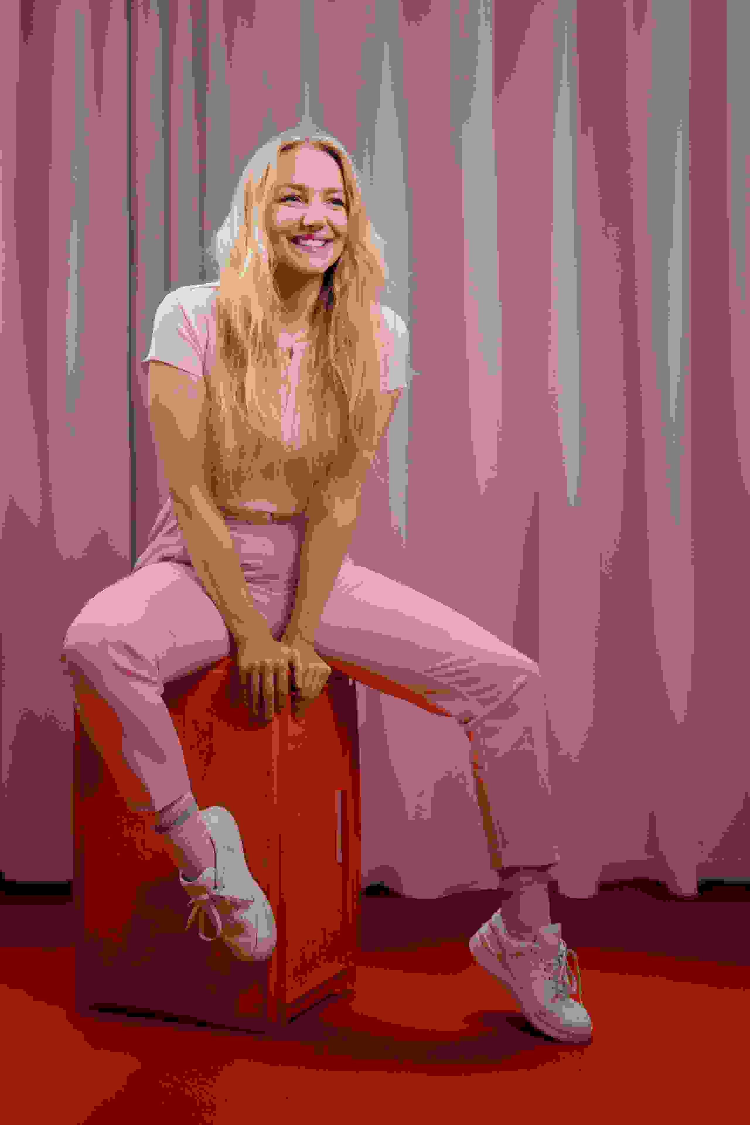 Mitarbeiterin Jenny Steiner der Live Kommunikations Agentur evenjo im rosa Outfit vor rosa Rückwand. live kommunikation, Corporate-Event, Eventagentur bern, eventplanung, firmenevents, teamevents bern, jubiläumsfeier, networking anlass, mitarbeiteranlass, evenjo-Team, Technik, Backoffice, Admin