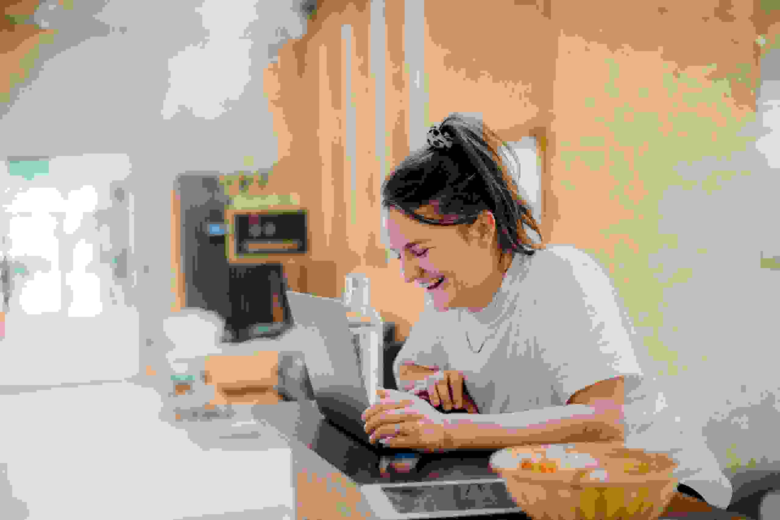 Lachende Mitarbeiterin Laura Wyss, Projektleiterin bei evenjo, in kreativen Agentur mit Laptop. Teamwork, Eventmanagement, Live-Kommunikation, Brand Experience, Markenerlebnis, Eventagentur Bern, Projektleitung, Beratung, evenjo-Team