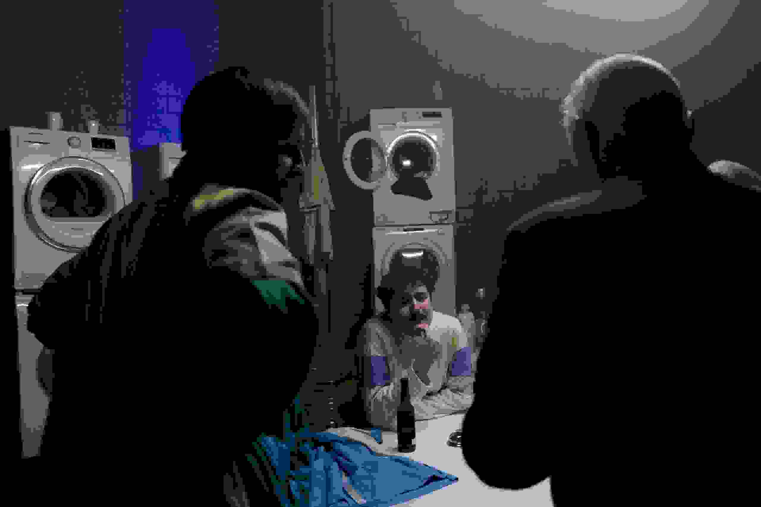 Drei Gäste erleben eine Inszenierung im Waschsalon mit Retro-Charme – kreative Eventlocation und überraschende Erlebnisse bei der evenjo Sause. Waschsalon, Retro-Inszenierung, Eventlocation, immersive Szenografie, Überraschungsmoment, markenerlebnis, Brand Experience, mitarbeiteranlass, live kommunikation, Corporate-Event, Markenerlebnis, eventplanung, jubiläumsfeier, mitarbeiteranlass, teamevent, Dekoration
