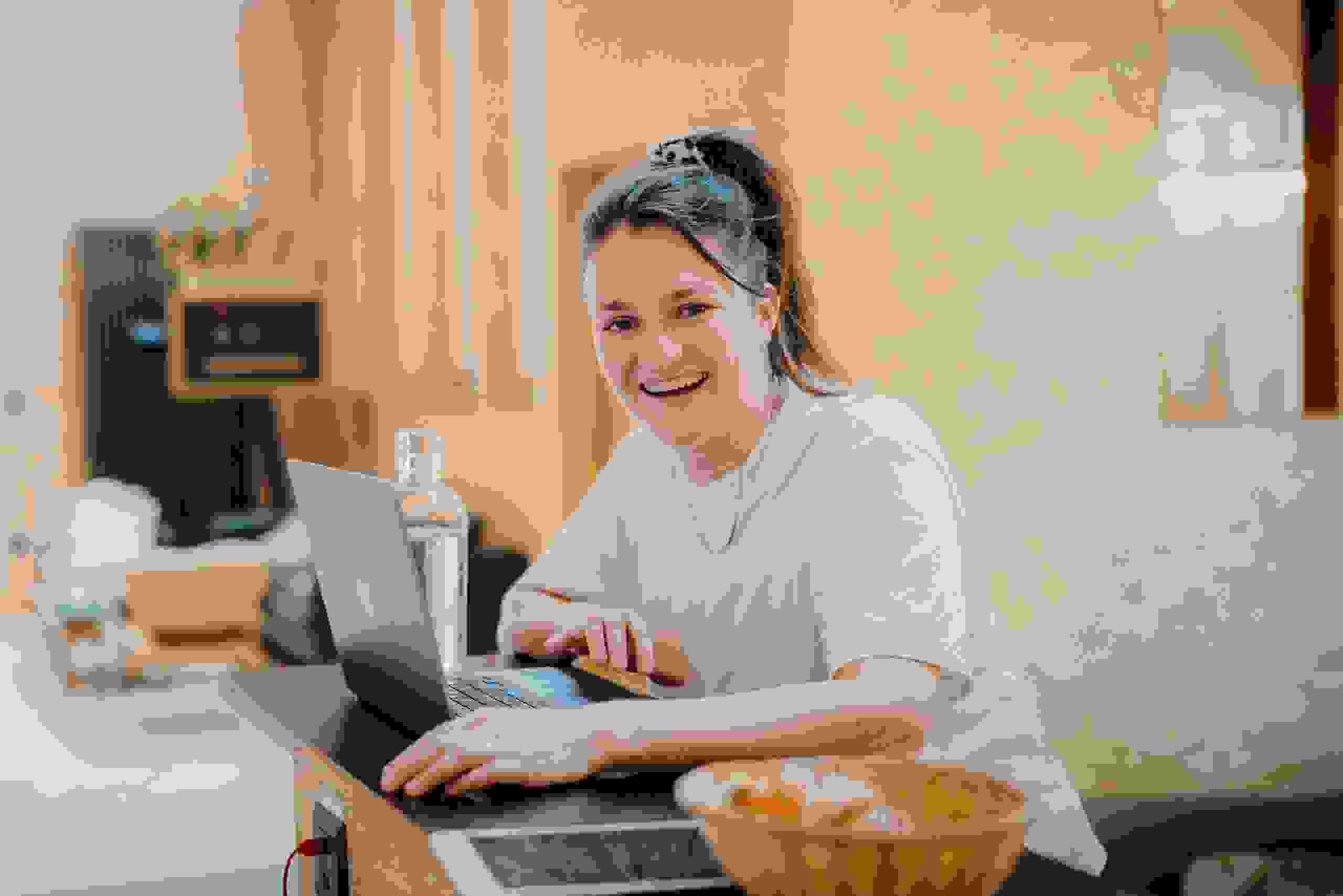 Lachende Mitarbeiterin Laura Wyss, Projektleiterin bei evenjo, in kreativen Agentur mit Laptop. Teamwork, Eventmanagement, Live-Kommunikation, Brand Experience, Markenerlebnis, Eventagentur Bern, Projektleitung, Beratung, evenjo-Team