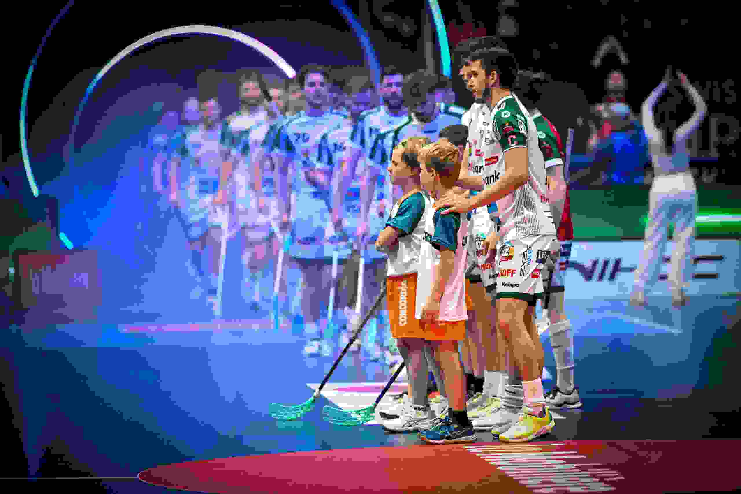 Das Team bereitet sich mit Einlaufkindern auf den Superfinal vor. konzentrierte Stimmung vor dem Anpfiff unter Lichtinszenierung.Unihockey Superfinal, Teampräsentation, Einlaufkinder, Sportevent, Floorball Schweiz, Lichtshow, Spielbeginn, live kommunikation, Corporate-Event, Eventagentur bern, eventplanung, firmenevents, teamevents bern, jubiläumsfeier, networking anlass, mitarbeiteranlass, evenjo-Team, Technik, Public Events, Sport und Entertainment Events, markenerlebnis, Brand Experience, Corporate-Event, Lichtshow, Eröffnungsshow