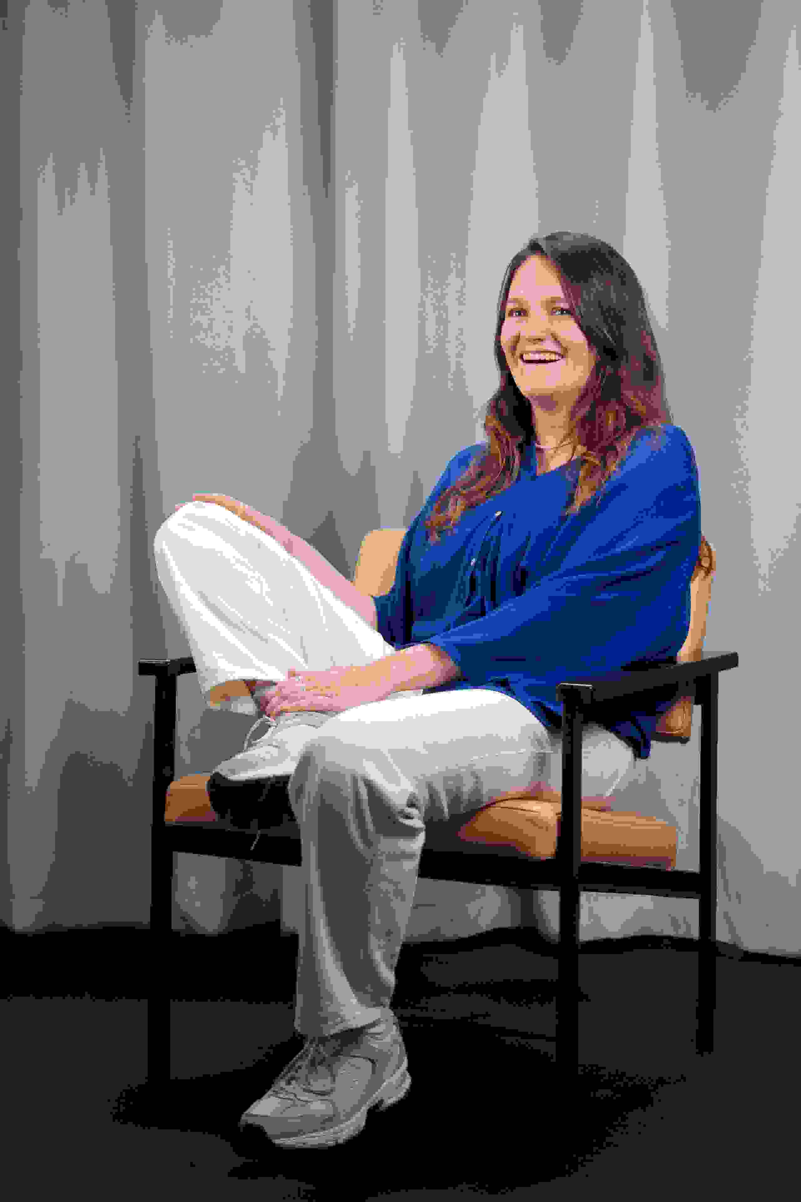 Mitarbeiterin Laura Wyss der Live Kommunikations Agentur evenjo mit blauer Bluse vor hellblauem Vorhang, authentisches Porträt. live kommunikation, Corporate-Event, Eventagentur bern, eventplanung, firmenevents, teamevents bern, jubiläumsfeier, networking anlass, mitarbeiteranlass, evenjo-Team, Technik, Projektleitung, Beratung