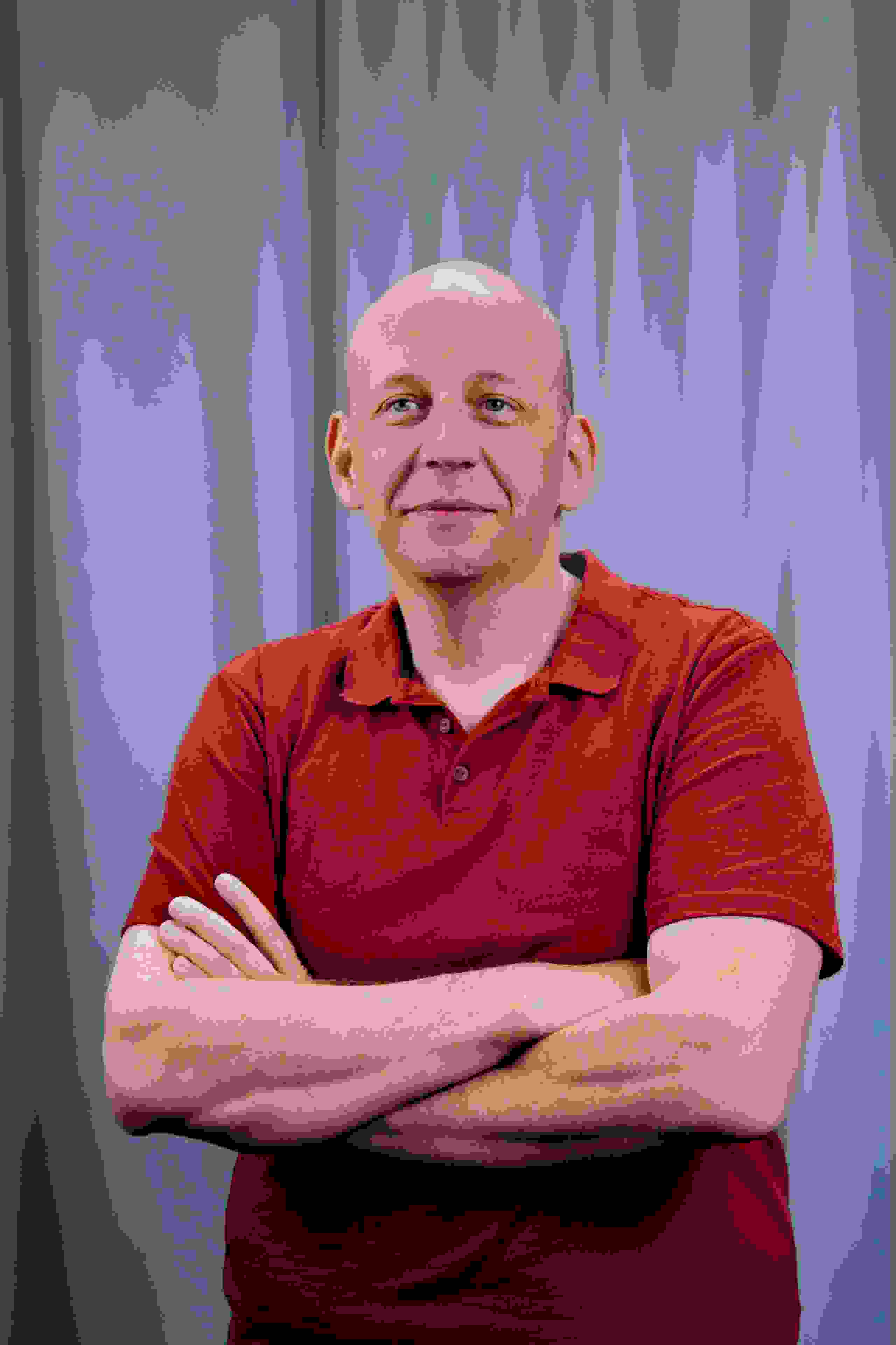 Mitarbeiter Christian "Polä" Wenger der Live Kommunikations Agentur evenjo mit rotem Shirt vor blauem Hintergrund. live kommunikation, Corporate-Event, Eventagentur bern, eventplanung, firmenevents, teamevents bern, jubiläumsfeier, networking anlass, mitarbeiteranlass, evenjo-Team, Technik, Technischer Leiter
