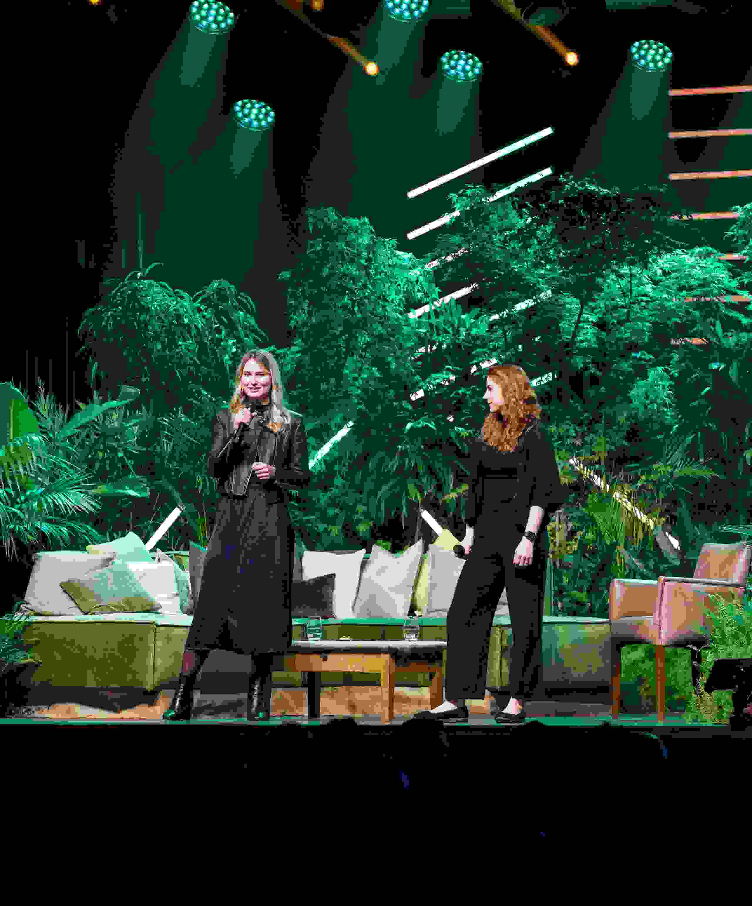 Fabienne Heer & Rahel Schaad auf Dschungel-Bühne beim Unfold 2024 – Live-Kommunikation, Eventmoderation, Business-Event in Bern. Corporate Event, Eventbühne, Eventdesign, grüne Lichtstimmung, Dschungel Deko, Business Event, live kommunikation, Eventagentur bern, eventplanung, firmenevents, teamevents bern, jubiläumsfeier, networking anlass, mitarbeiter:innenanlass, Technik, Public Events, Sport und Entertainment Events, markenerlebnis, Brand Experience