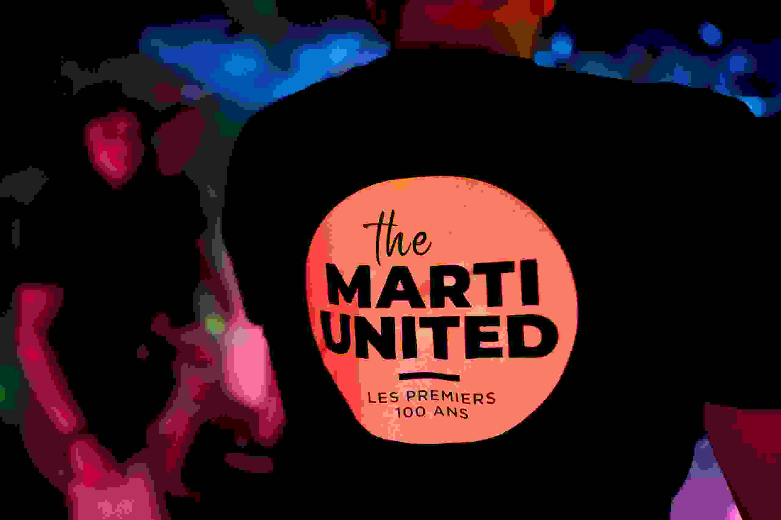 Marti United 100 T-Shirt bei Nachtaufnahme mit leuchtendem Logo während des Events. Marti United 100, Firmenshirt, Nachtaufnahme, Branding, Jubiläumsfeier, Eventkleidung, Corporate Identity, Markenerlebnis, Brand Experience, Live Kommunikation, Corporate-Event, eventplanung, Jubiläumsfeier, Mitarbeiteranlass, Teamevent, 100 Jahre Marti AG, Festival