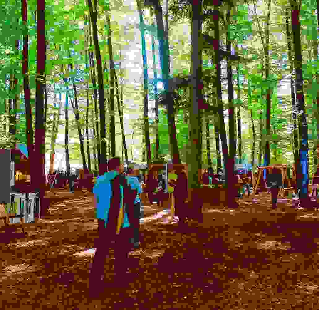 Besucher:innen erkunden das XPLORE Event im Wald – Natur trifft auf Erlebniswelten. markenerlebnis, Brand Experience, mitarbeiteranlass, live kommunikation, Corporate-Event, eventagentur bern, BKW, XPLORE, Outdoor Event, Markenerlebnis, eventplanung, jubiläumsfeier, mitarbeiteranlass