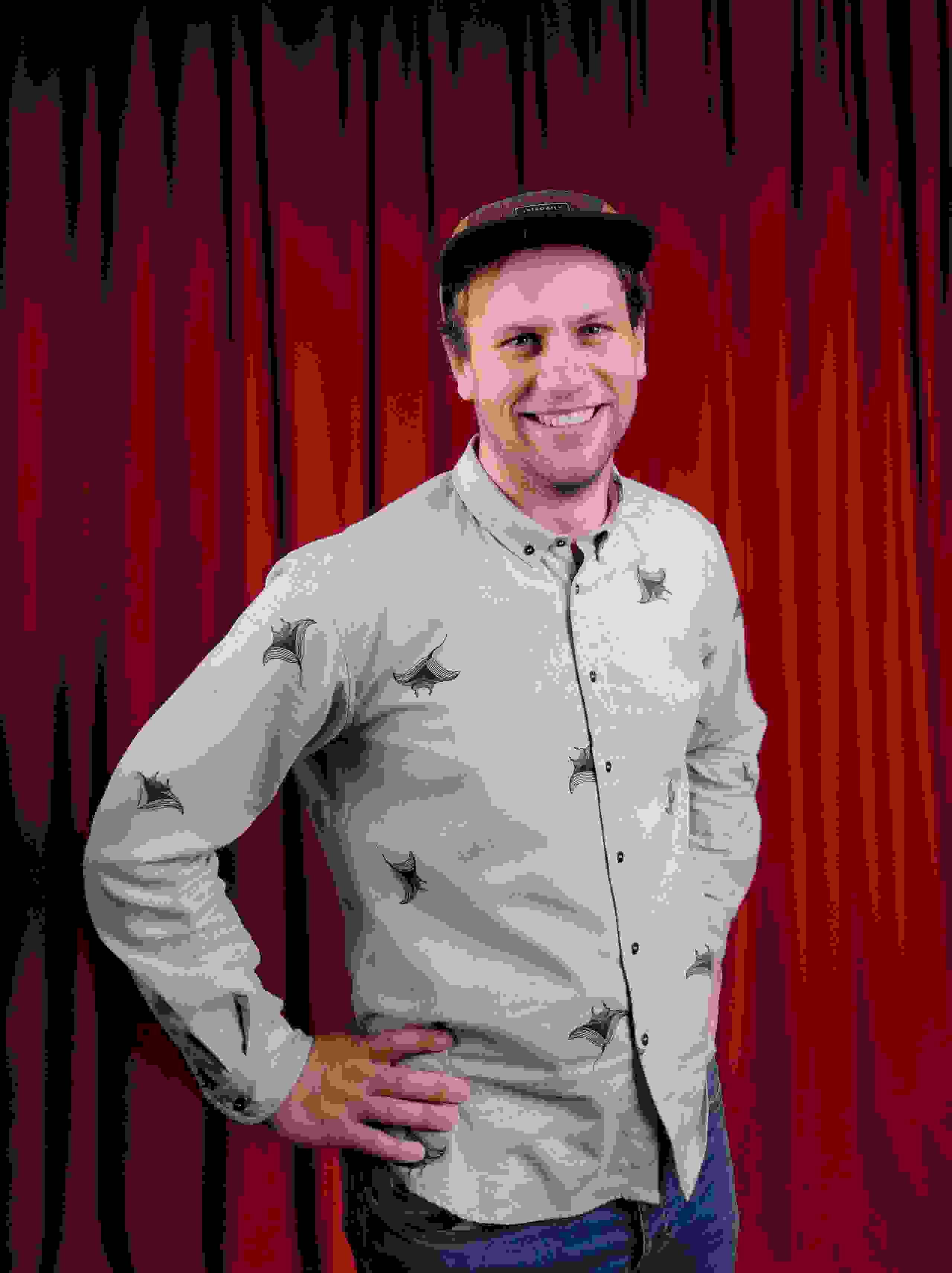 Mitarbeiter Nico Stähli der Live Kommunikations Agentur evenjo mit Hemd vor rotem Vorhang. live kommunikation, Corporate-Event, Eventagentur bern, eventplanung, firmenevents, teamevents bern, jubiläumsfeier, networking anlass, mitarbeiteranlass, evenjo-Team, Technik, Konzepter, Content Director, Social Media, Krea