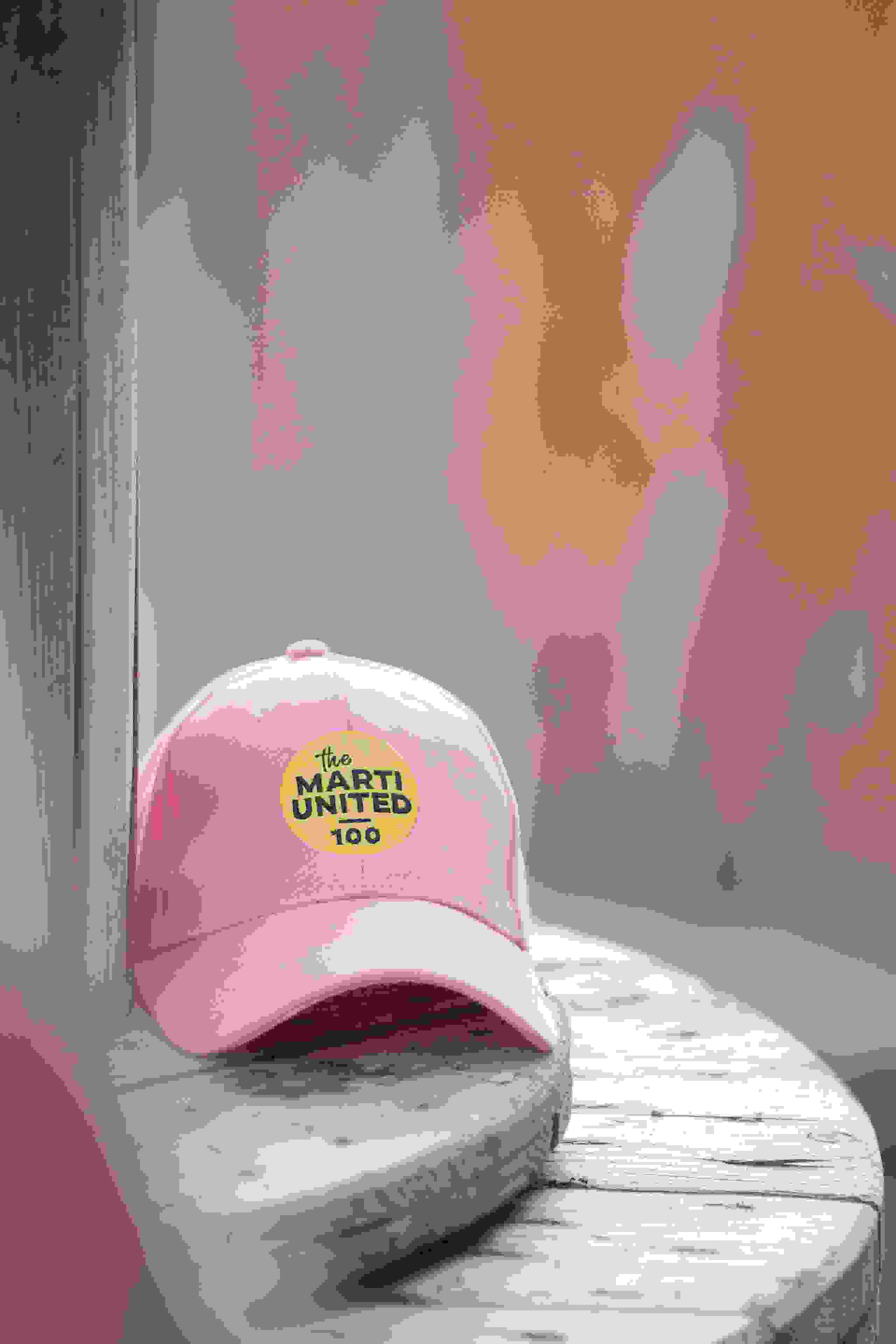 Rosa Cap mit dem Marti United 100 Logo als Merchandise-Artikel zum Firmenjubiläum. Marti United 100, Merchandise, Cap, Jubiläumsgeschenk, Event-Souvenir, Branding, Firmenevent, Give Away, Markenerlebnis, Brand Experience, Mitarbeiteranlass, Live Kommunikation, Corporate-Event
