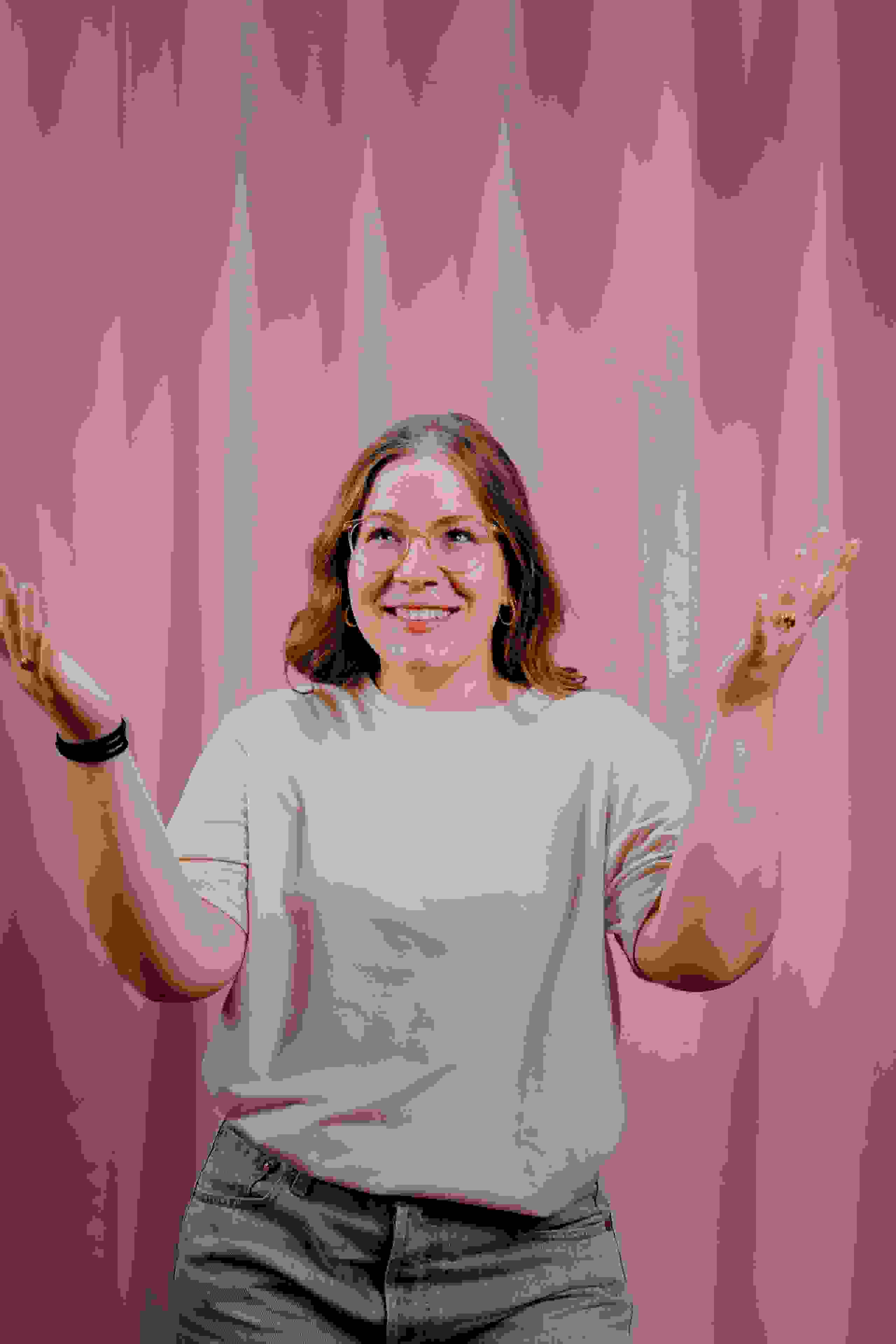 Mitarbeiterin Assja Stämpfli der Live Kommunikations Agentur evenjo vor rosa Hintergrund mit offener Geste. live kommunikation, Corporate-Event, Eventagentur bern, eventplanung, firmenevents, teamevents bern, jubiläumsfeier, networking anlass, mitarbeiteranlass, evenjo-Team, Technik, Krea, Konzepterin, Polydesignerin 3D