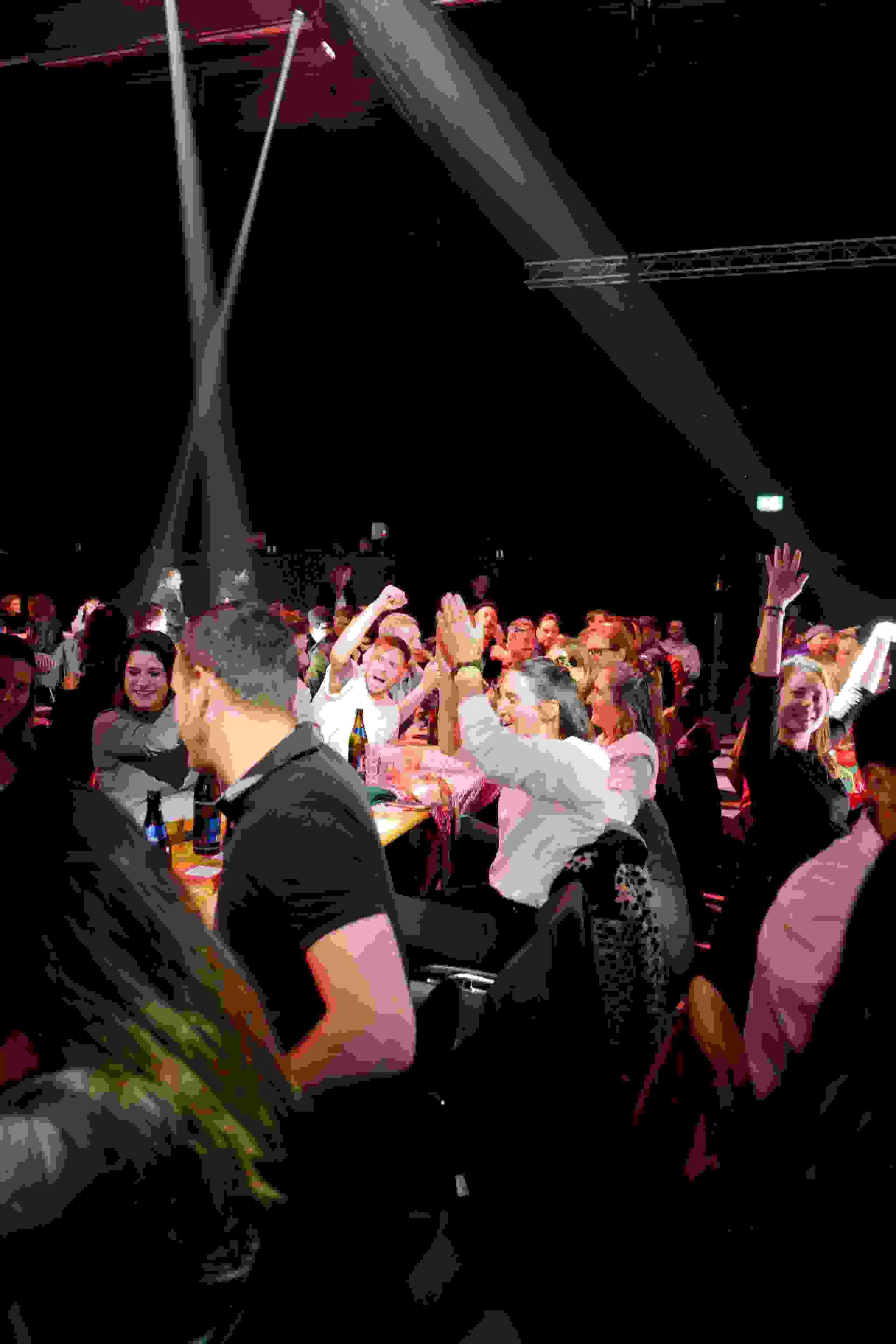 Grosse Gruppe von Gästen jubelt und feiert in festlicher Stimmung – ausgelassene Atmosphäre beim Superlotto-Publikumsevent. Publikumsfreude, Festivalfeeling, Superlotto, Jubel, Eventerlebnis, Eventtechnik, live kommunikation, 
markenerlebnis, Corporate-Event, eventagentur bern, eventplanung