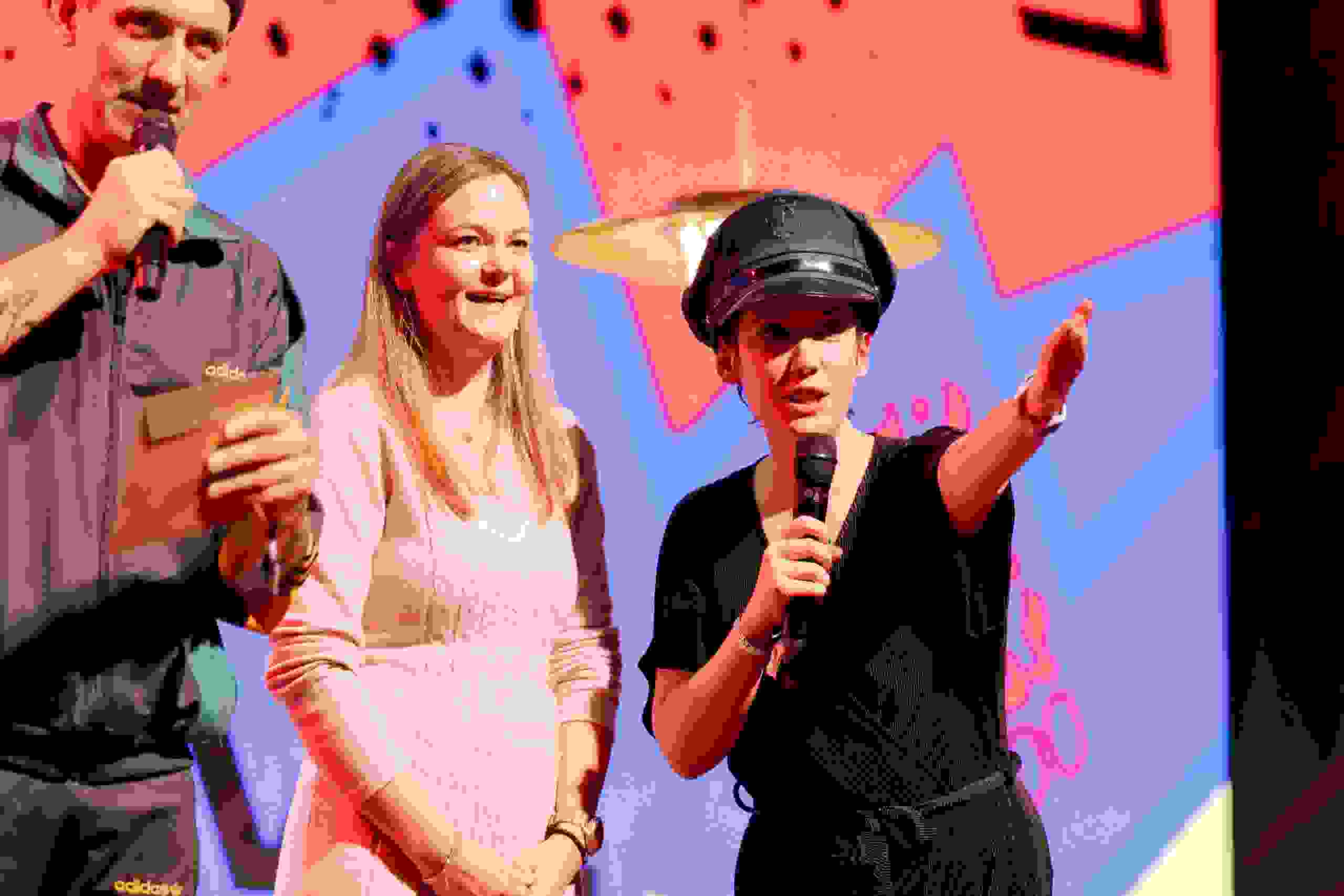 Moderatorin Gülsha Adilji mit Mikrofon und Polizei-Hut führt charmant durch das Programm – humorvolle Bühnenmoderation mit Überraschungselementen. Bühnenmoderation, Publikumsnähe, Eventhumor, Supermercado, Show, eventagentur bern
eventplanung, Eventtechnik, live kommunikation, teamevents, Corporate-Event, bernexpo