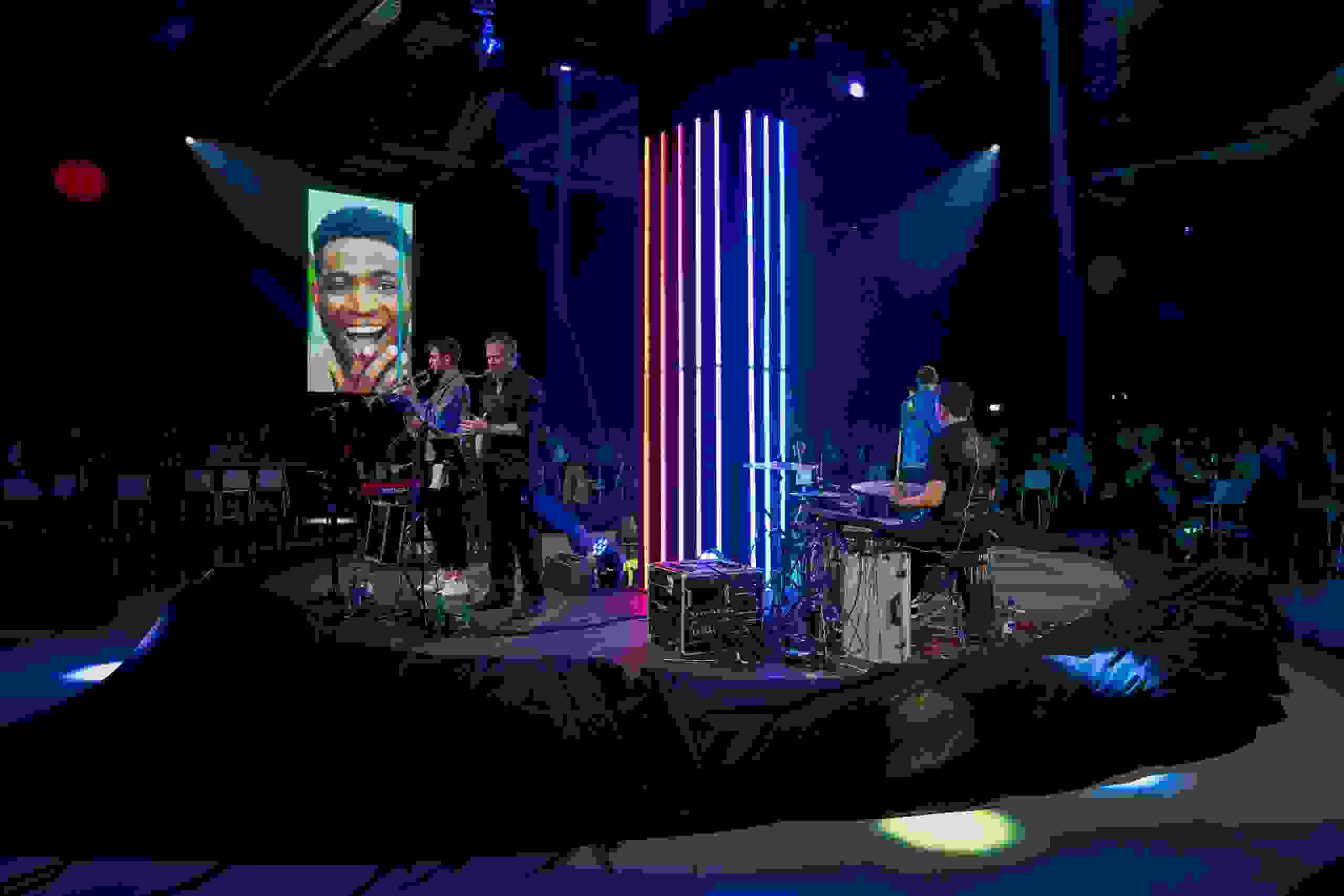 Liveband-Performance auf einer zentralen Eventbühne mit LED-Lichtinstallation – musikalisches Highlight und visuelles Erlebnis bei einem innovativen Corporate-Event. Liveband, Corporate Event, Eventbühne, Markenerlebnis, Eventbeleuchtung, Business Event, Brand Experience, Publikum, Leadership, Motivation, Corporate Speaker, Innovation, Markeninszenierung, eventagentur bern, markenerlebnis, Brand Experience