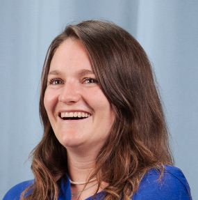 Mitarbeiterin Laura Wyss der Live Kommunikations Agentur evenjo lachend mit blauer Bluse vor hellblauem Vorhang, authentisches Porträt. live kommunikation, Corporate-Event, Eventagentur bern, eventplanung, firmenevents, teamevents bern, jubiläumsfeier, networking anlass, mitarbeiteranlass, evenjo-Team, Technik, Projektleitung, Beratung