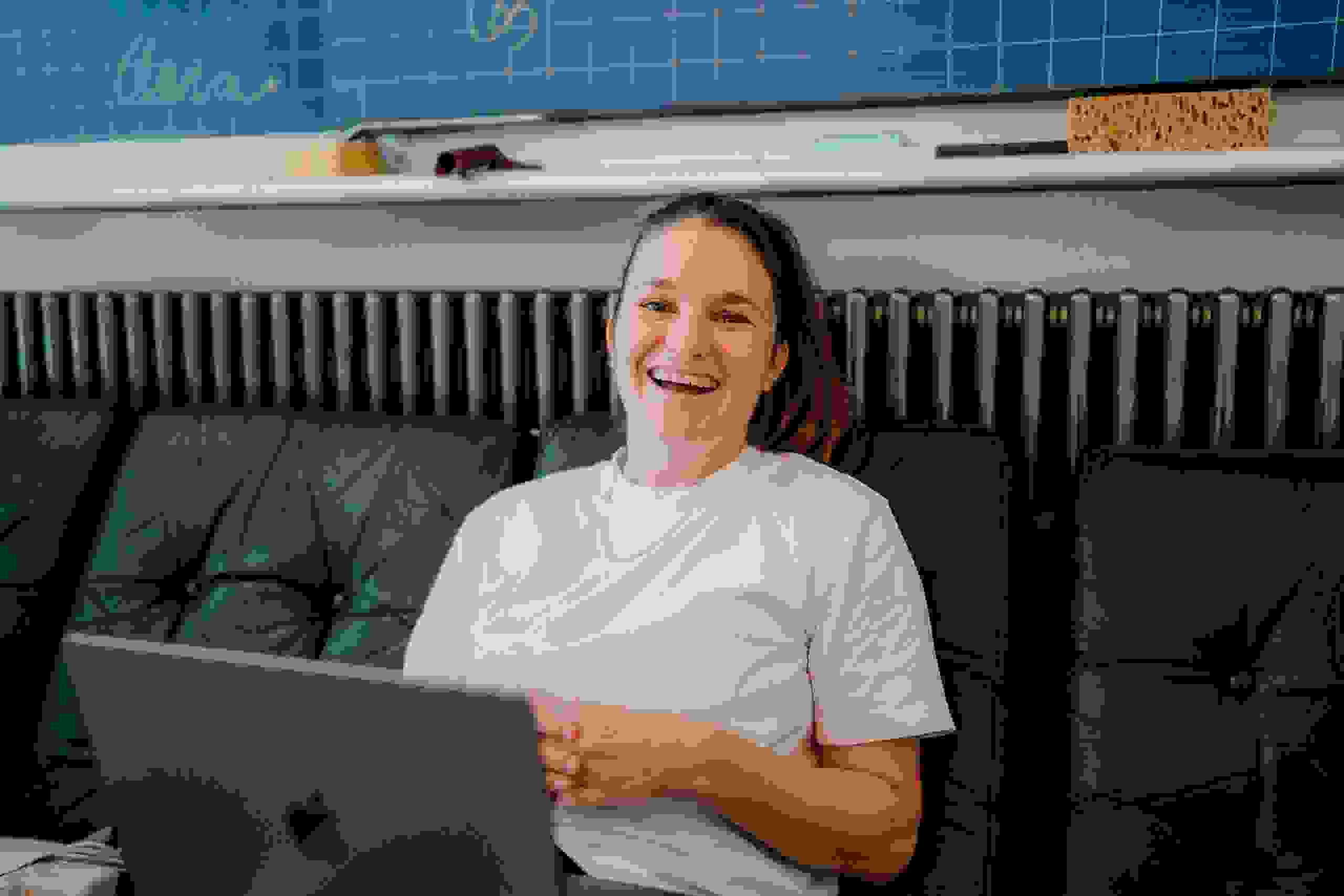 Lachende Mitarbeiterin Laura Wyss, Projektleiterin bei evenjo, in kreativen Agentur mit Laptop. Teamwork, Eventmanagement, Live-Kommunikation, Brand Experience, Markenerlebnis, Eventagentur Bern, Projektleitung, Beratung, evenjo-Team