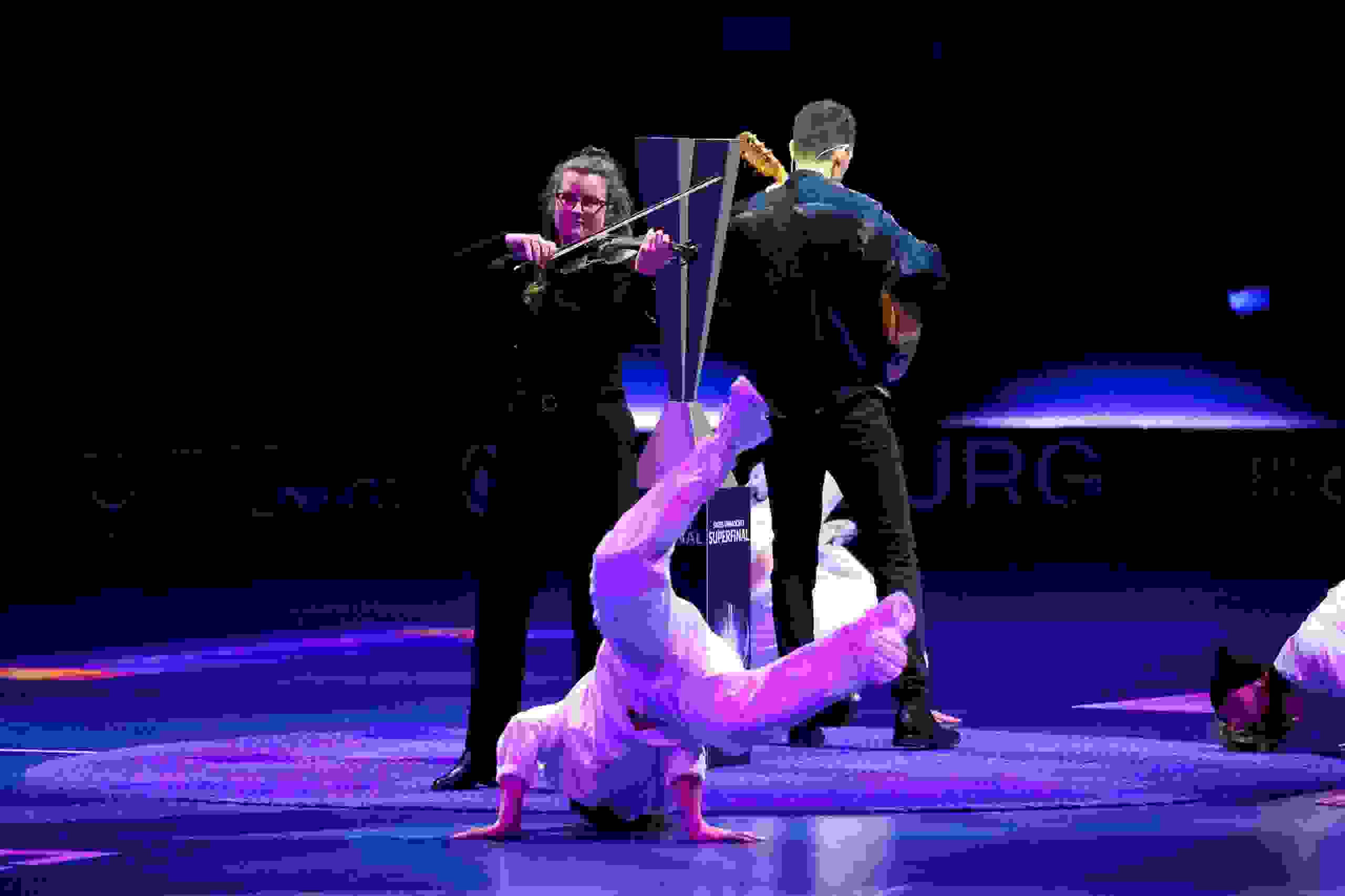 Künstlerische Showeinlage beim Unihockey Superfinal: Violinistin und Gitarrist spielen live während Breakdancer performen in der BCF Arena in Fribourg. live kommunikation, Corporate-Event, Eventagentur bern, eventplanung, firmenevents, teamevents bern, jubiläumsfeier, networking anlass, mitarbeiteranlass, evenjo-Team, Technik, Public Events, Sport und Entertainment Events, markenerlebnis, Brand Experience, Corporate-Event