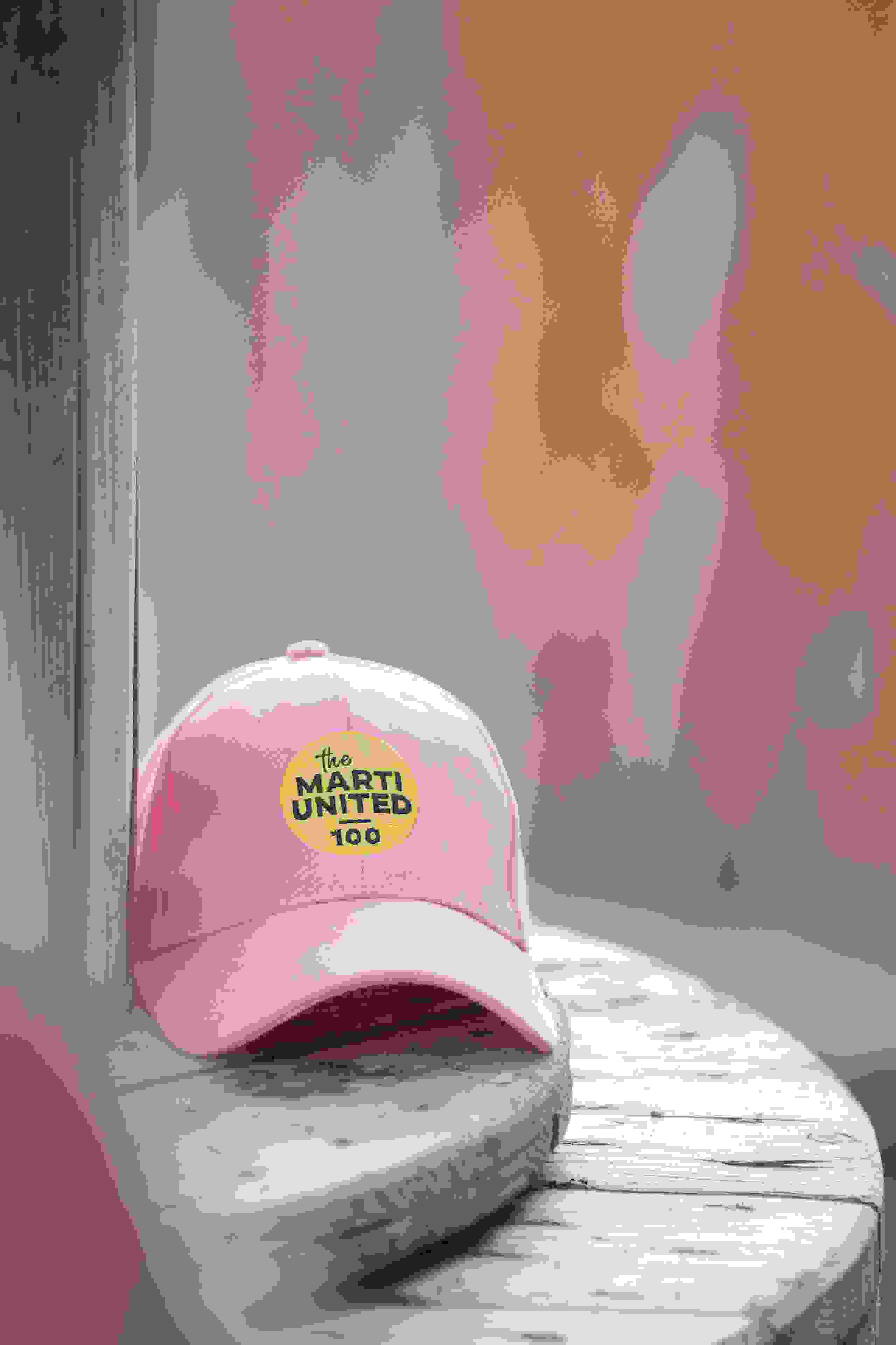 Rosa Cap mit dem Marti United 100 Logo als Merchandise-Artikel zum Firmenjubiläum. Marti United 100, Merchandise, Cap, Jubiläumsgeschenk, Event-Souvenir, Branding, Firmenevent, Give Away, Markenerlebnis, Brand Experience, Mitarbeiteranlass, Live Kommunikation, Corporate-Event