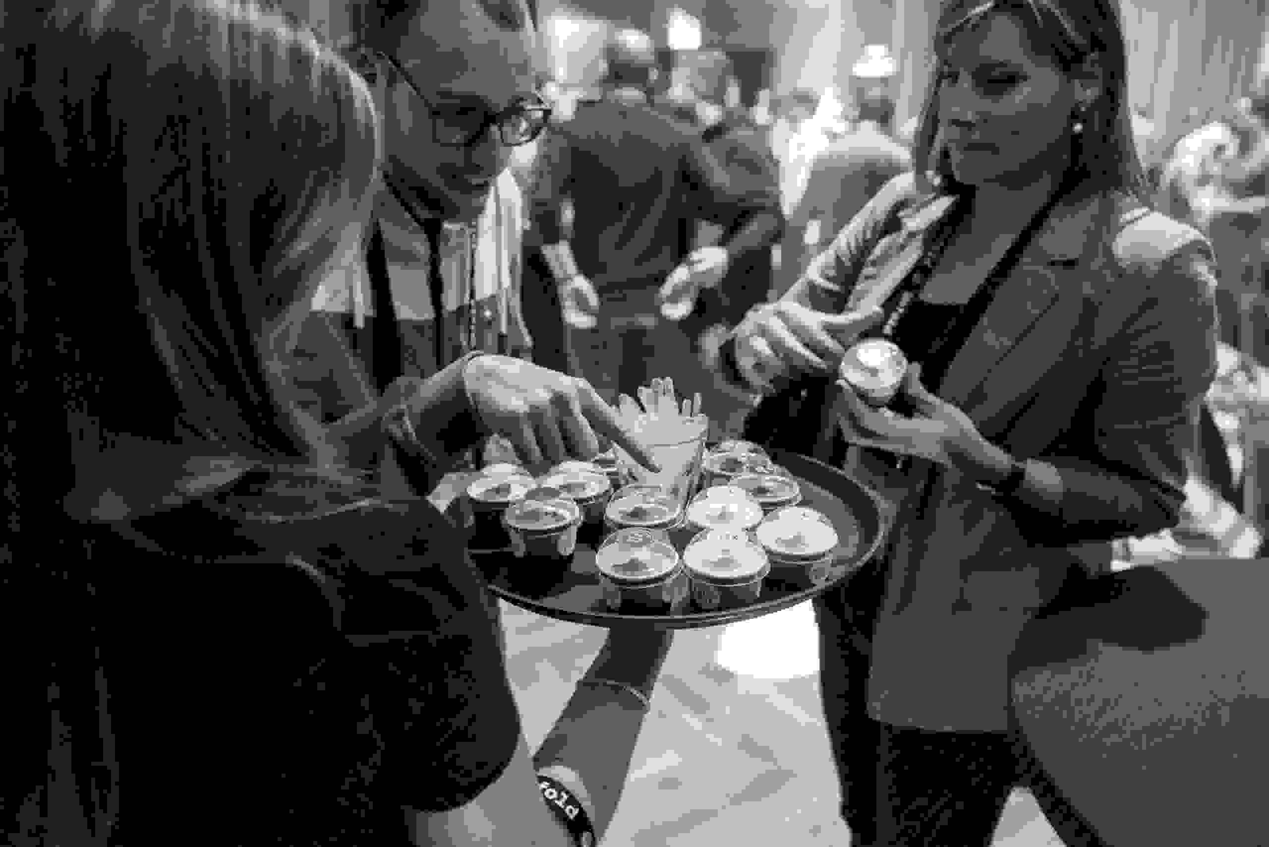 Schwarz-Weiß-Aufnahme von Gästen beim Catering mit Fingerfood – Business-Event. Corporate Event, Eventbühne, Eventdesign, grüne Lichtstimmung, Dschungel Deko, Business Event, live kommunikation, Eventagentur bern, eventplanung, firmenevents, teamevents bern, jubiläumsfeier, networking anlass, mitarbeiter:innenanlass, Technik, Public Events, Sport und Entertainment Events, markenerlebnis, Brand Experience