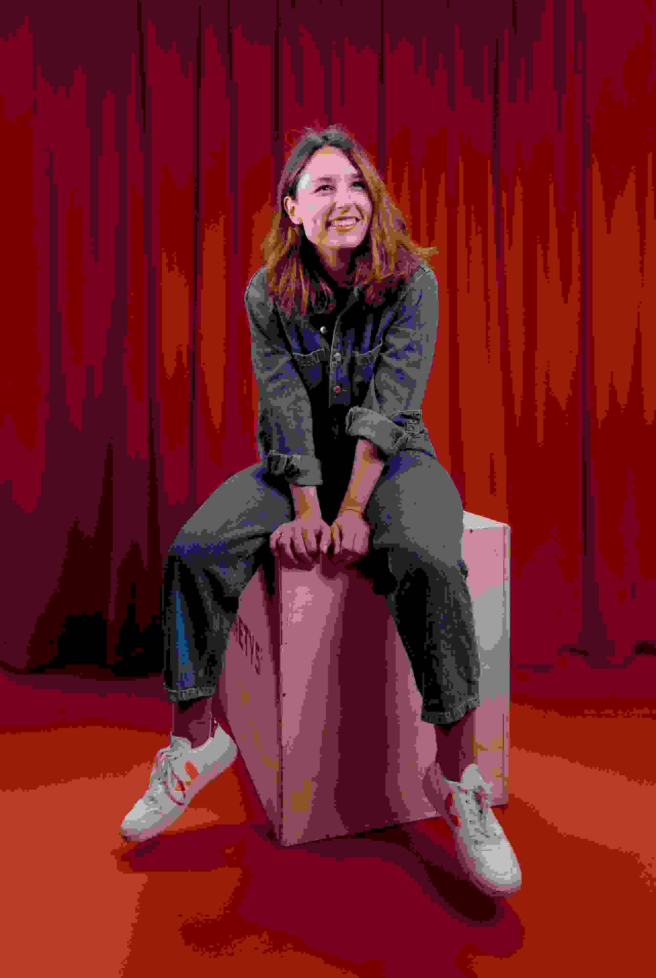 Mitarbeiterin Anja Mosimann der Live Kommunikations Agentur evenjo in Jeansoutfit vor rotem Vorhang, live kommunikation, Corporate-Event, Eventagentur bern, eventplanung, firmenevents, teamevents bern, jubiläumsfeier, networking anlass, mitarbeiteranlass, evenjo-Team, Krea, Art Director