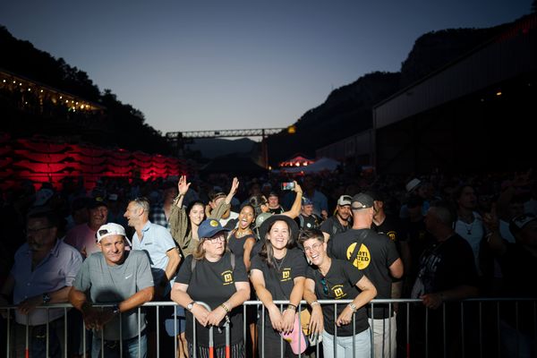 Besucher:innen in Feierlaune vor der Bühne beim Marti United 100 Event in der Abenddämmerung. Marti United 100, Publikum, Nachtstimmung, Firmenjubiläum, Besucher:innen, Eventfreude, Stimmung, Festival, Markenerlebnis, Brand Experience, Mitarbeiteranlass, Live Kommunikation, Corporate-Event, eventplanung, 100 Jahre Marti AG