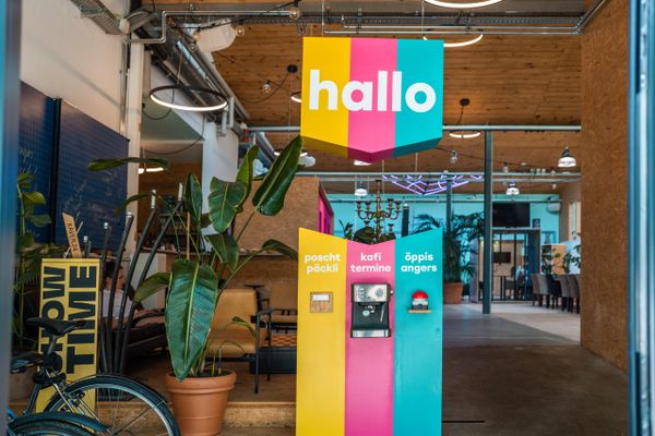 Bunter Empfangsbereich mit Kaffeeautomat und „Hallo“-Schild bei evenjo. einladende Büroatmosphäre, Teamevent, Betriebsausflug, Markenerlebnis, Brand Experience, Eventplanung, Publicevent, Eventagentur Bern, Corporate-Event, Mitarbeiteranlass, Mitarbeiter:innen-Anlass, Live Kommunikation, networking Anlass, Teambuilding, Teamspirit, kreative Arbeitsumgebung, einladende Büroatmosphäre, kreative Agentur, Kreativworkshops, Eventlogistik, kreative Arbeitsräume.