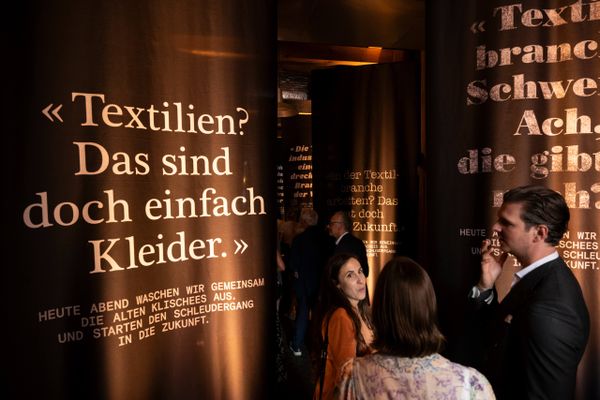 Grossflächige veraltete Zitate auf Stoffbahnen regen zum Nachdenken an – immersive Ausstellung zur Zukunft der Textilbranche. Textilzukunft, Statement-Design, Immersive Ausstellung, Branchenkritik, Swiss Textiles, markenerlebnis, Brand Experience, Riithalle Zürich, Dekoration, jubiläumsfeier, mitarbeiteranlass, live kommunikation