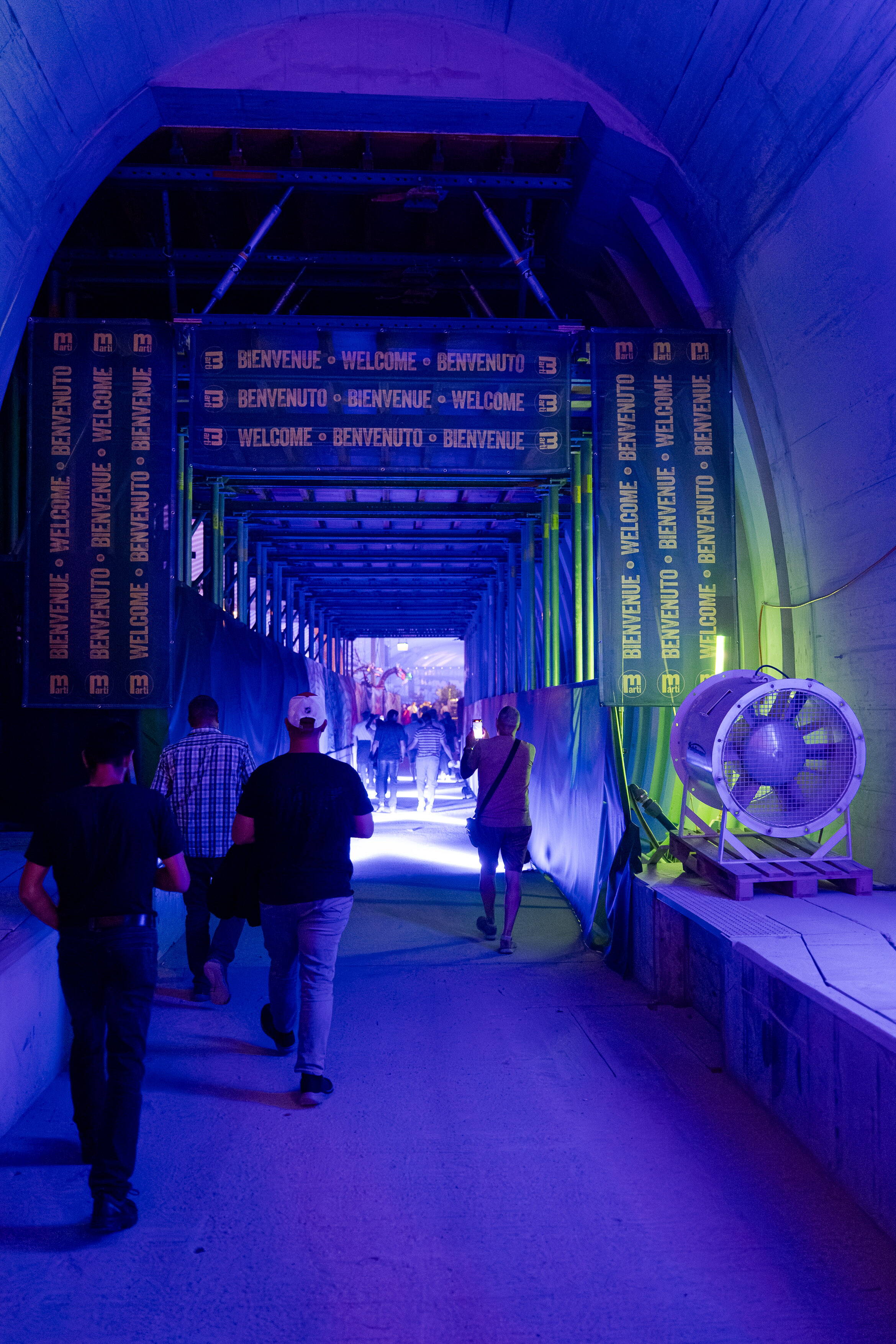 Gäste betreten durch einen beleuchteten Tunnel mit «Welcome»-Schildern die Event-Kaverne der BLS-Baustelle Bern.