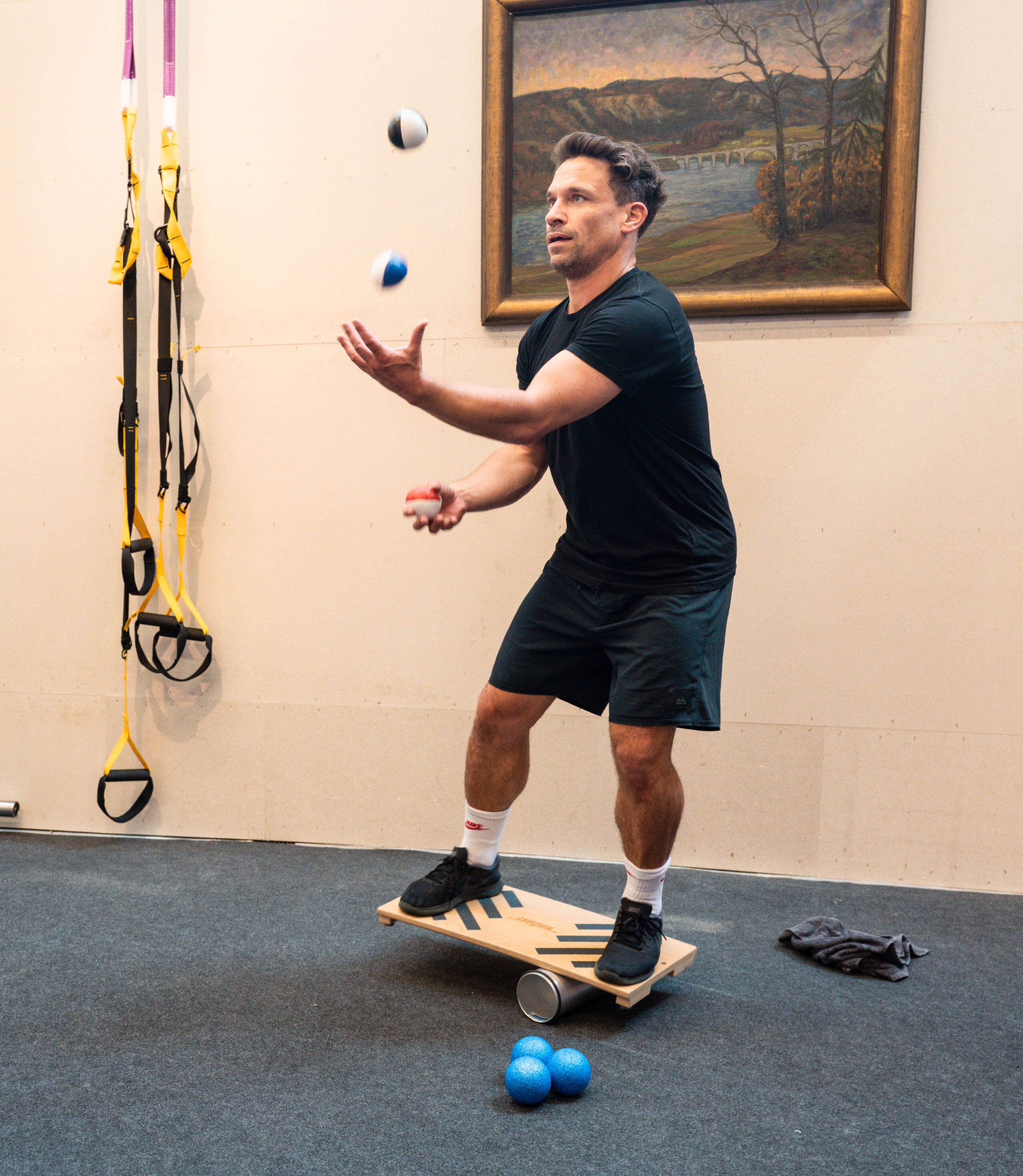 fitness_eventagentur-bern-5.jpg Daniel Schmutz jongliert auf Balance-Board während Fitness-Session bei evenjo im Gym. Koordination, Geschicklichkeit, Teambuilding, Sport, Teamwork, Bewegung, Gesundheitsförderung, Eventplanung, Live-Kommunikation, Brand Experience, Markenerlebnis, Eventagentur Bern, Unik
