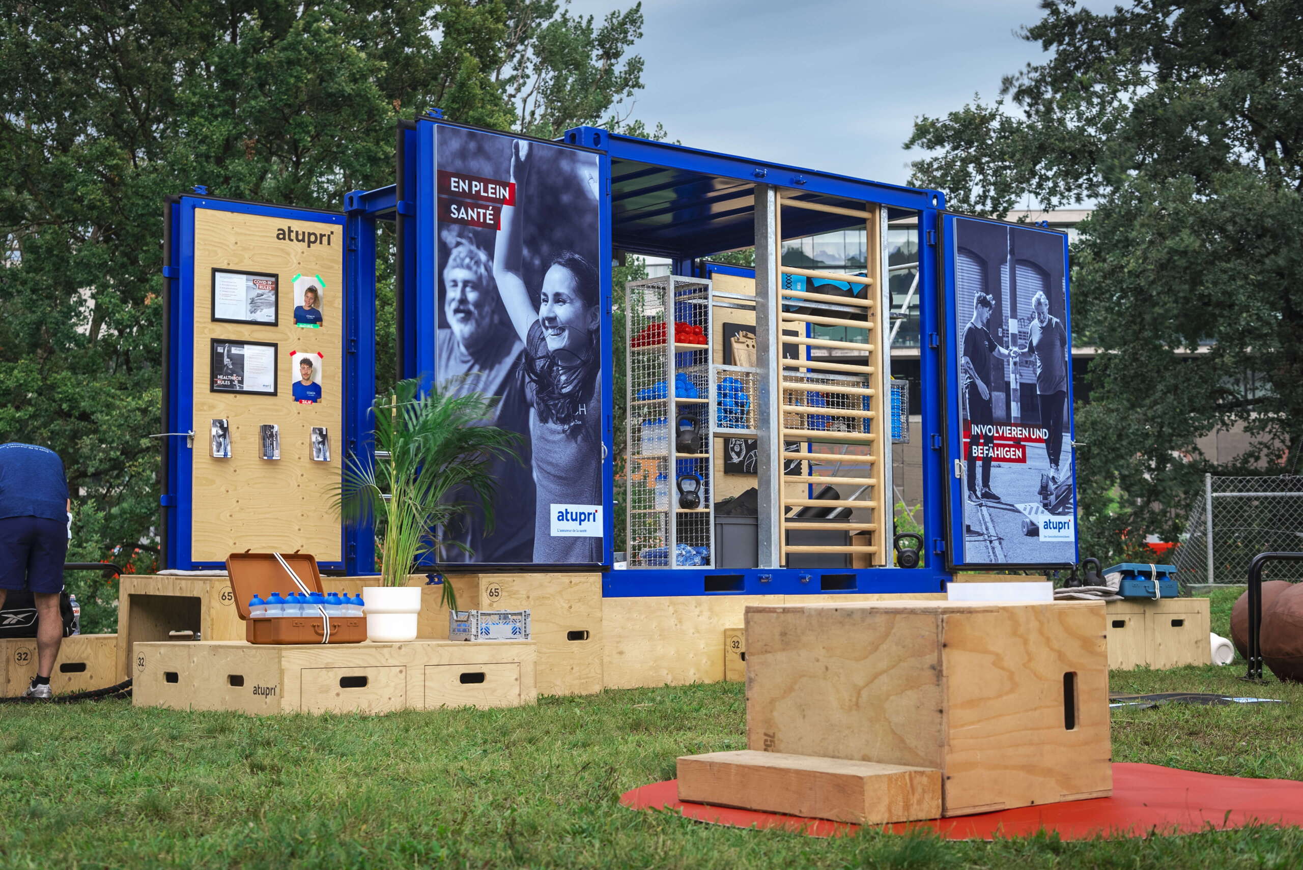 evenjo-ag-eventagentur-bern-atupri-healthbox-2.jpg Die Atupri Healthbox mit moderner Fitnessausstattung und inspirierenden Gesundheitsbotschaften auf Eventwiese. Atupri Healthbox, mobile Fitnessstation, Gesundheitsevent, Trainingscontainer, Eventmodul, live kommunikation, Corporate-Event, Eventagentur bern, eventplanung, firmenevents, teamevents bern, jubiläumsfeier, networking anlass, mitarbeiteranlass, Technik, Public Events, Sport und Entertainment Events, markenerlebnis, Brand Experience
