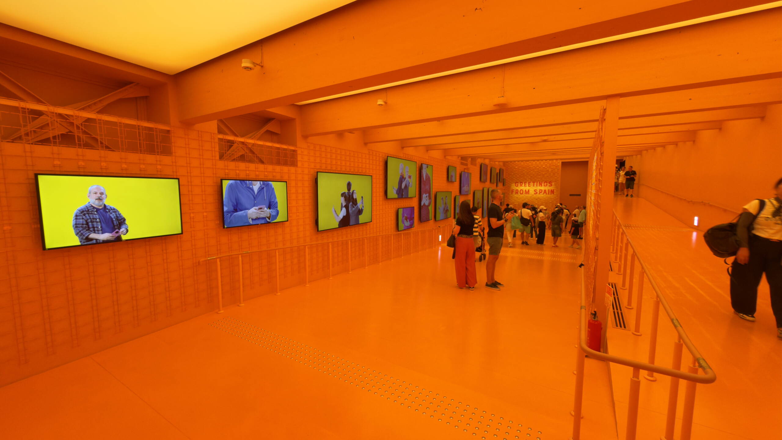 Multimedialer Pavillon an der Expo Osaka mit grossformatigen Screens und orangefarbener Raumgestaltung