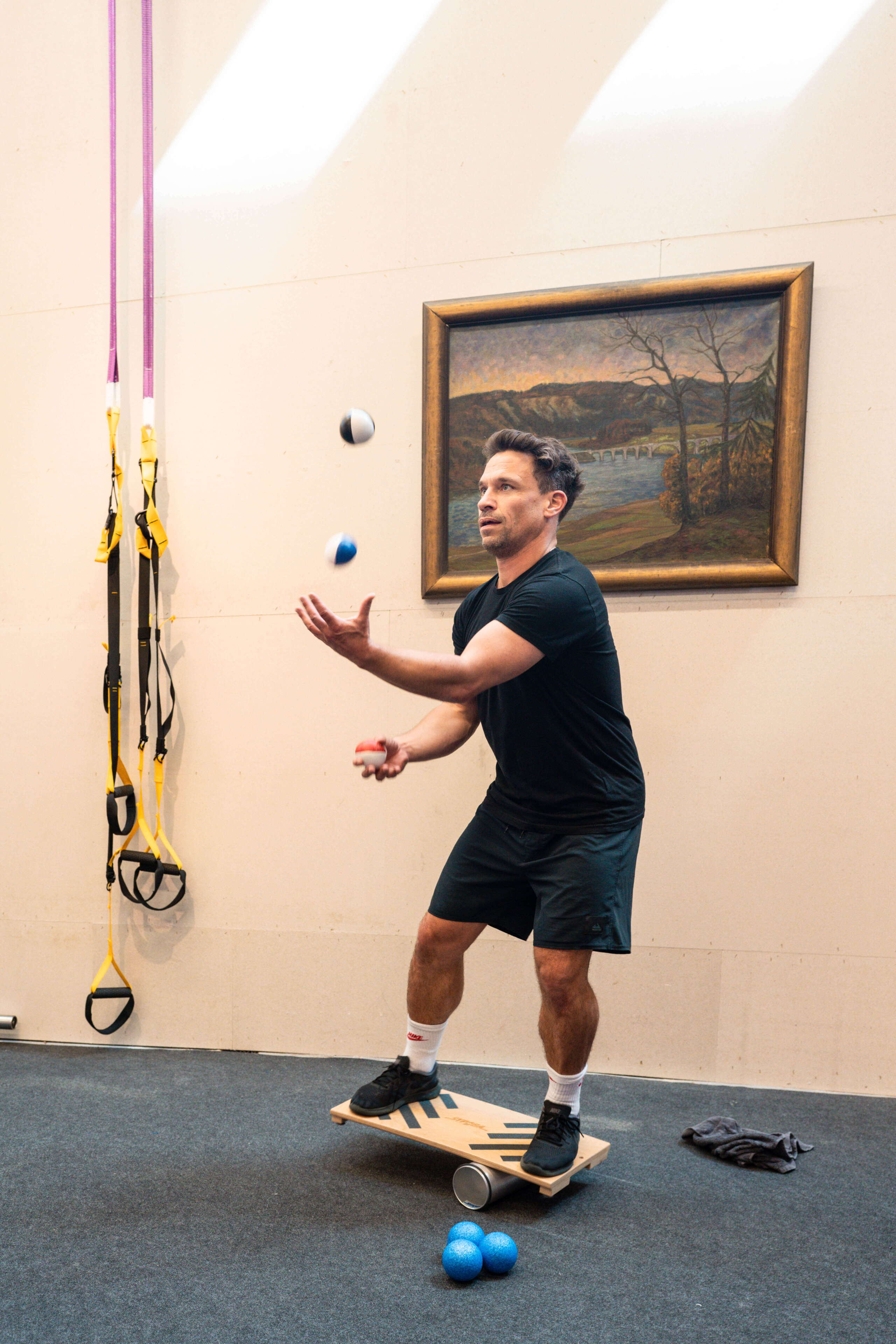 fitness_eventagentur-bern-5.jpg Daniel Schmutz jongliert auf Balance-Board während Fitness-Session bei evenjo im Gym. Koordination, Geschicklichkeit, Teambuilding, Sport, Teamwork, Bewegung, Gesundheitsförderung, Eventplanung, Live-Kommunikation, Brand Experience, Markenerlebnis, Eventagentur Bern, Unik