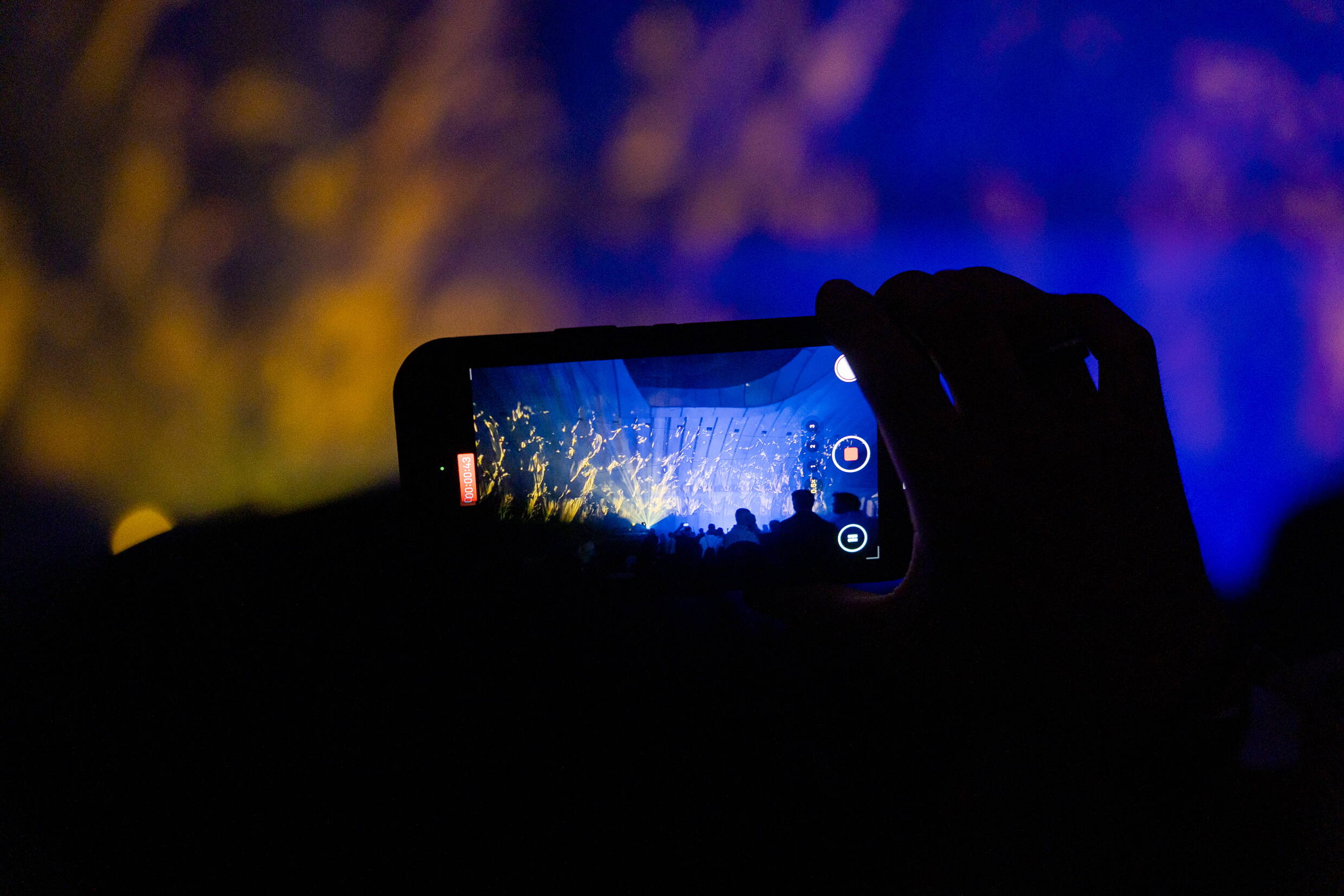 Ein Gast filmt die Licht- und Musikshow in der Kaverne der BLS-Baustelle Bern mit dem Smartphone.