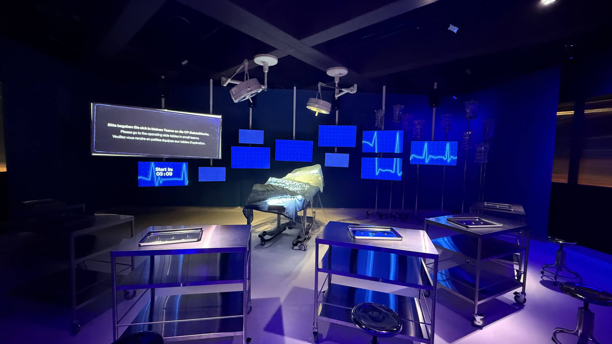 evenjo_ausstellung_stapferhaus_szenografie_inszenierung.jpeg Ausstellungsraum im Stapferhaus mit OP-Tisch, Monitoren und moderner Szenografie. Ausstellungsgestaltung, Inszenierung, Begegnung, Networking, Live-Kommunikation, Eventgestaltung, Markenerlebnis, Brand Experience, Eventplanung, Publicevent, Eventagentur Bern, Corporate-Event, Mitarbeiteranlass, Mitarbeiter:innen-Anlass, Live Kommunikation, networking Anlass