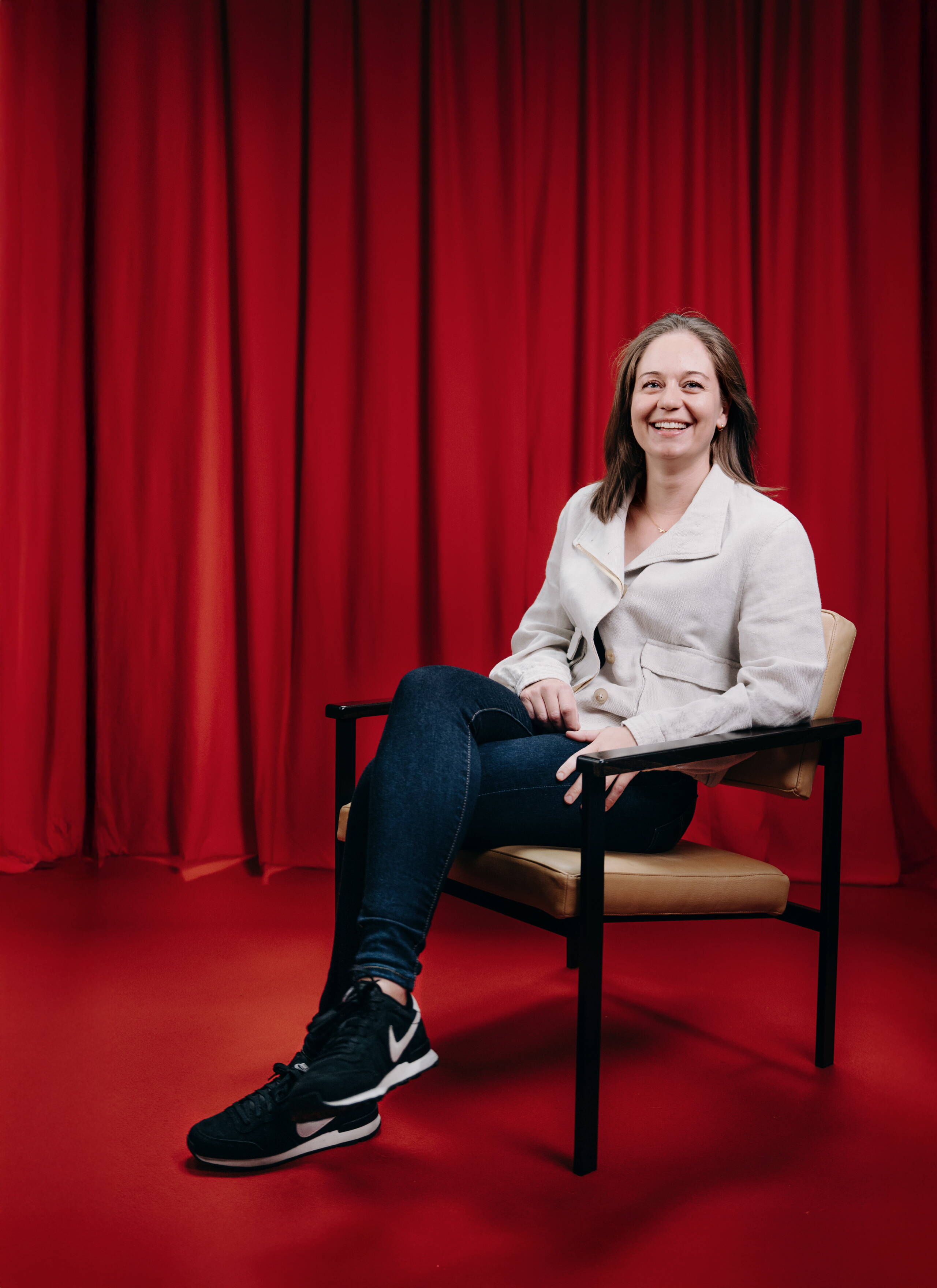 carola-kunz.jpg Mitarbeiterin Carola Kunz der Live Kommunikations Agentur evenjo sitzt entspannt auf einem Stuhl vor rotem Hintergrund, modernes Portraitfoto, live kommunikation, Corporate-Event, Eventagentur bern, eventplanung, firmenevents, teamevents bern, jubiläumsfeier, networking anlass, mitarbeiteranlass, Finanzfachfrau, Treuhänderin, evenjo-Team