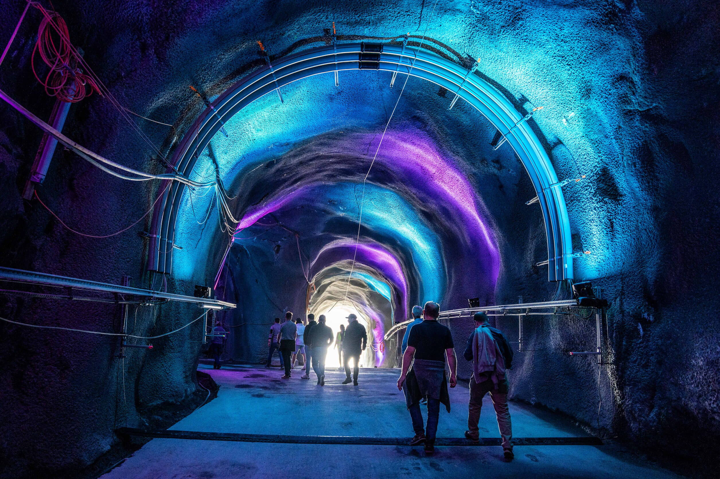 Farbige Lichtinstallation in einem Bergstollen während des Events – immersive Inszenierung im Inneren der Grimsel.