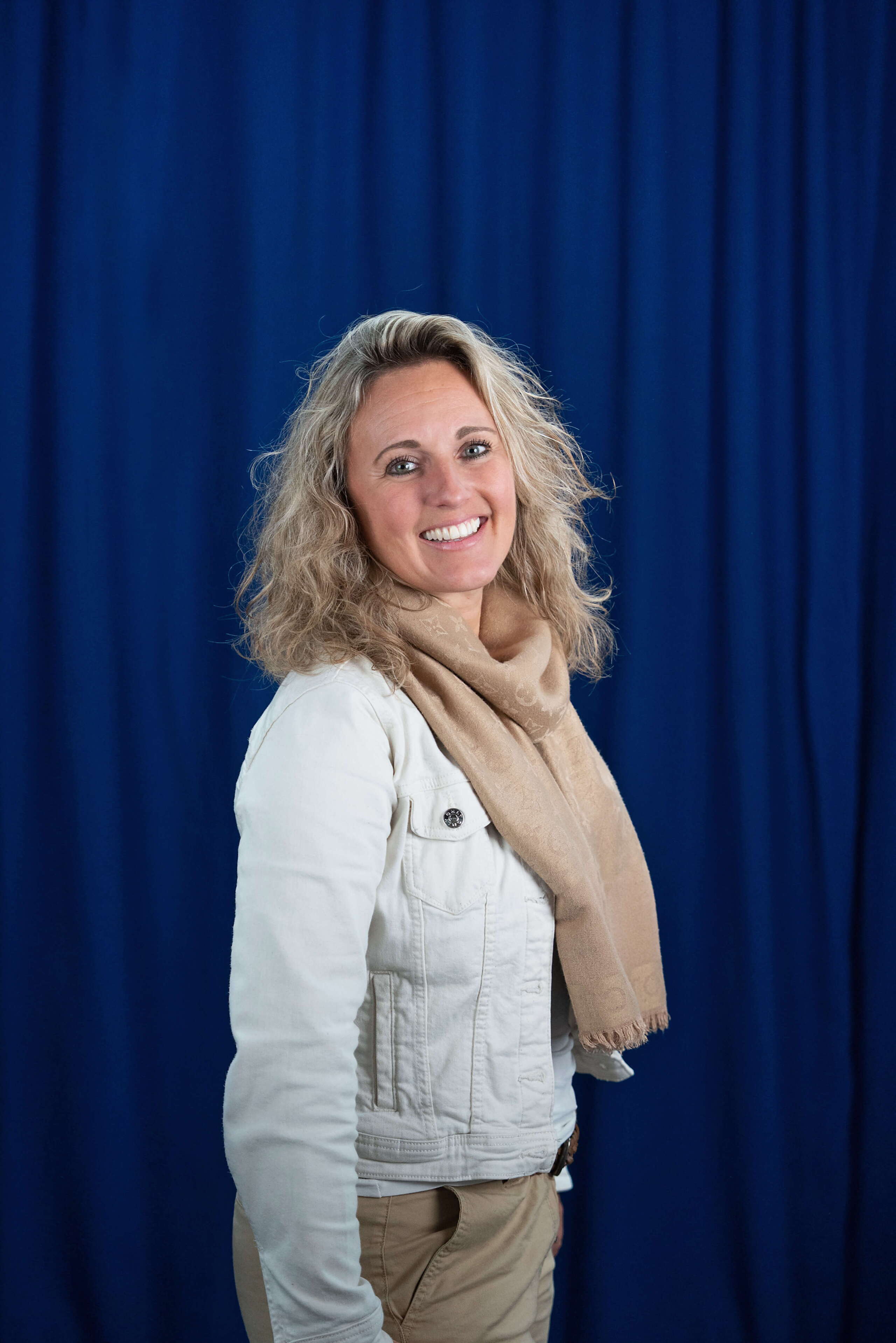 Mitarbeiterin Corinne Zimmermann mit offenen Armen vor blauem Hintergrund der Live Kommunikations Agentur evenjo. live kommunikation, Corporate-Event, Eventagentur bern, eventplanung, firmenevents, teamevents bern, jubiläumsfeier, networking anlass, mitarbeiteranlass, evenjo-Team, Technik, Mitglied Geschäftsleitung, Senior Projektleitung, Beratung