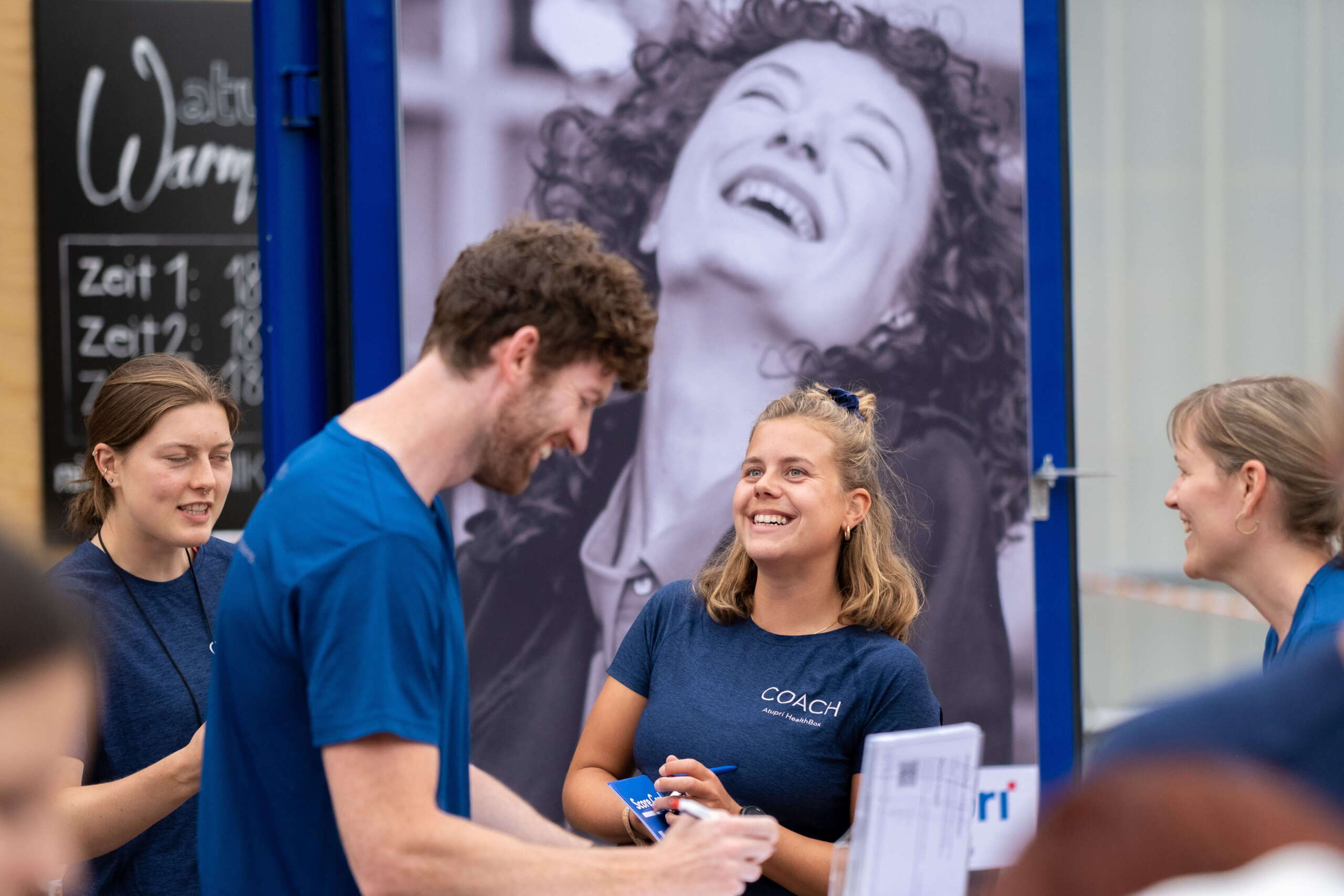 evenjo-ag-eventagentur-bern-atupri-healthbox-8.jpg Freundliche Coachin der Atupri Healthbox im motivierenden Gespräch mit einem Besucher am Gesundheitsevent. Gesundheitscoaching, persönlicher Austausch, Fitnessberatung, Motivation, Unik, live kommunikation, Corporate-Event, Eventagentur bern, eventplanung, firmenevents, teamevents bern, jubiläumsfeier, networking anlass, mitarbeiteranlass, Technik, Public Events, Sport und Entertainment Events, markenerlebnis, Brand Experience