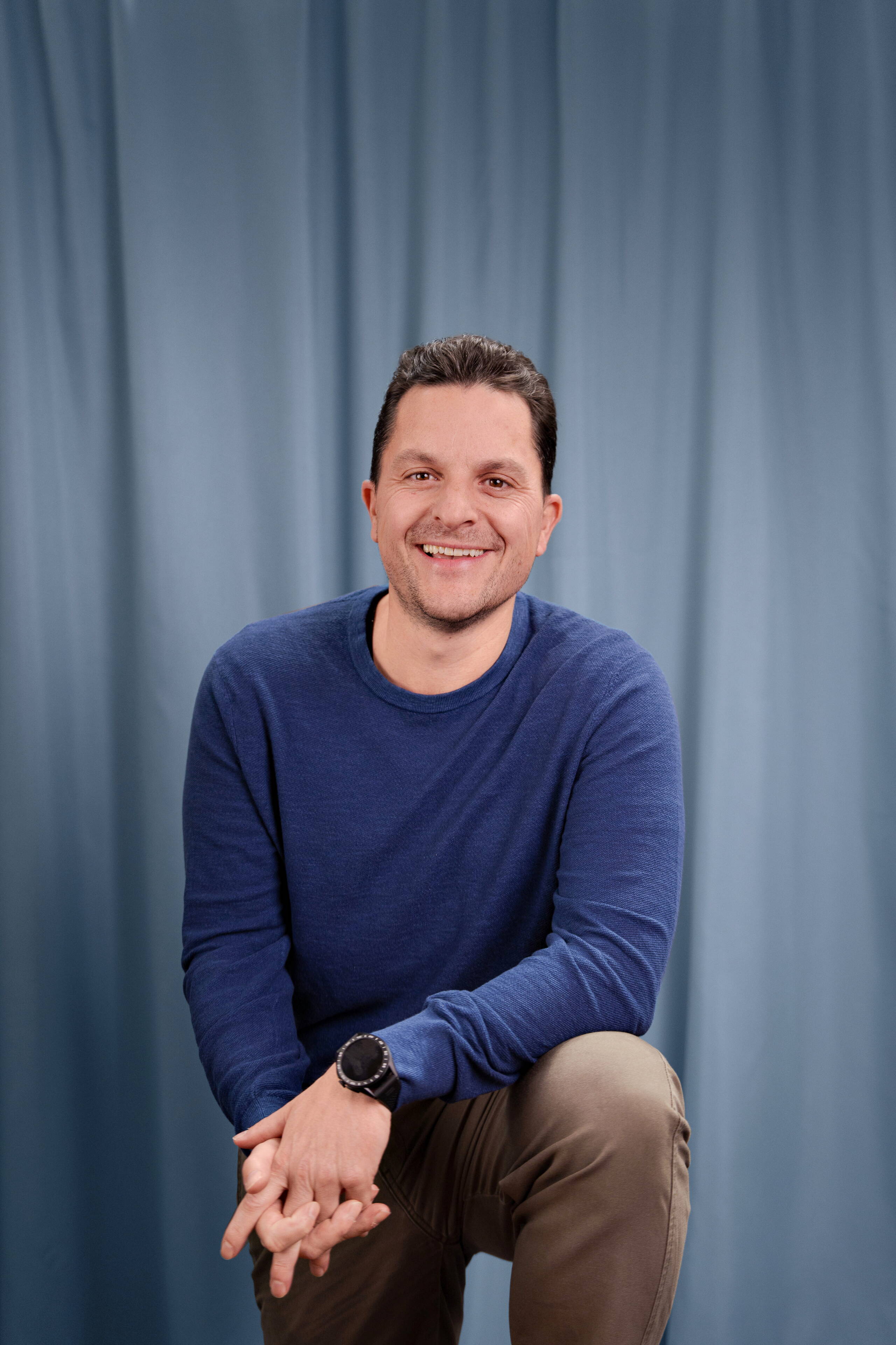 flavio-baggenstos.jpg Managing Partner Flavio Baggenstos der Live Kommunikations Agentur evenjo mit entspanntem Lächeln vor hellblauem Studiohintergrund. live kommunikation, Corporate-Event, Eventagentur bern, eventplanung, firmenevents, teamevents bern, jubiläumsfeier, networking anlass, mitarbeiteranlass, evenjo-Team, Technik, Finanzen, Inhaber