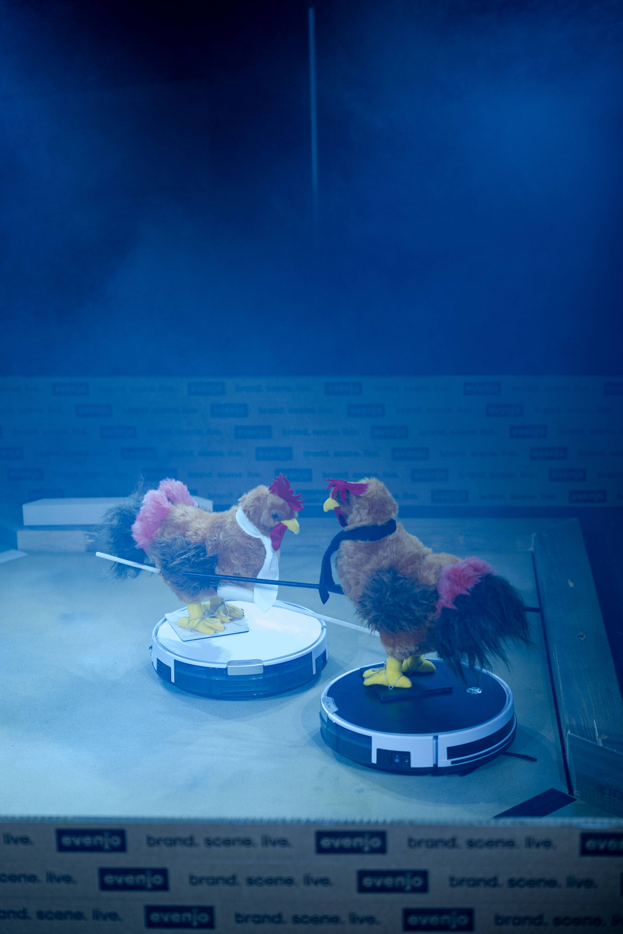evenjo-sause-plueschhahn_auf_Staubsauger.jpg Zwei Hähne auf Staubsaugern liefern sich ein humorvolles Duell im Nebel – innovatives Show-Element bei der evenjo Sause. Hahnenkampf, Roboter-Show, interaktives Event, Markeninszenierung, Eventinnovation, markenerlebnis, Brand Experience, mitarbeiteranlass, live kommunikation, Corporate-Event, Markenerlebnis, eventplanung, jubiläumsfeier, mitarbeiteranlass, teamevent, Spiel