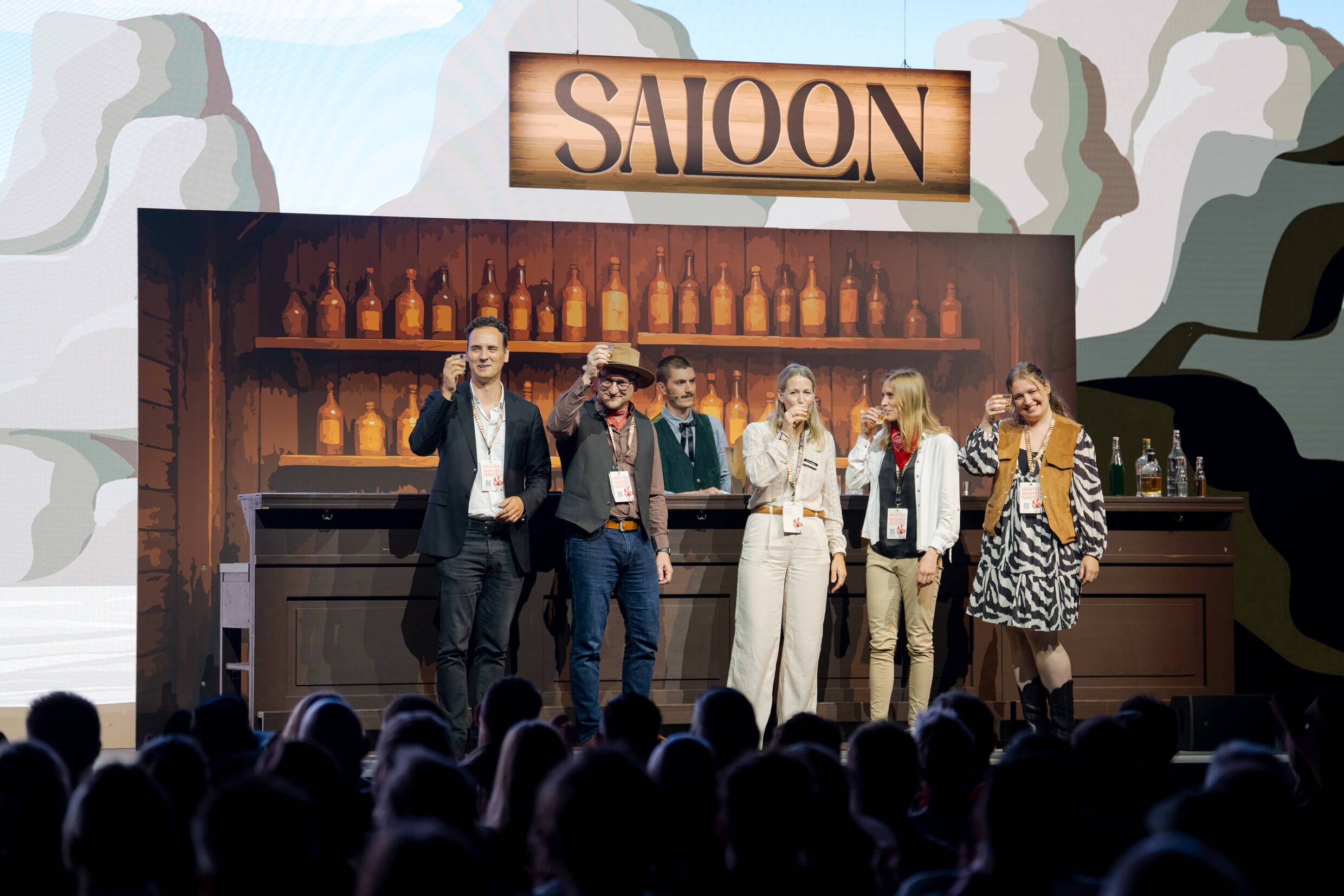 evenjo_xaveraward_preisverleihung_2.jpg Mehrere Personen stehen auf der Saloon-Bühne der XAVER Award Show 2025 und stossen gemeinsam an.