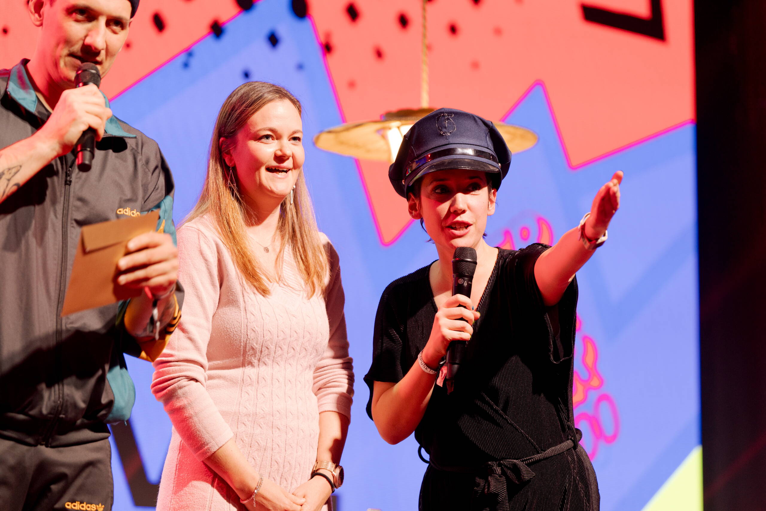 evenjo_gurtenfestival_superlotto_publicevent_bern_guelsha_adilji.jpg Moderatorin Gülsha Adilji mit Mikrofon und Polizei-Hut führt charmant durch das Programm – humorvolle Bühnenmoderation mit Überraschungselementen. Bühnenmoderation, Publikumsnähe, Eventhumor, Supermercado, Show, eventagentur bern
eventplanung, Eventtechnik, live kommunikation, teamevents, Corporate-Event, bernexpo