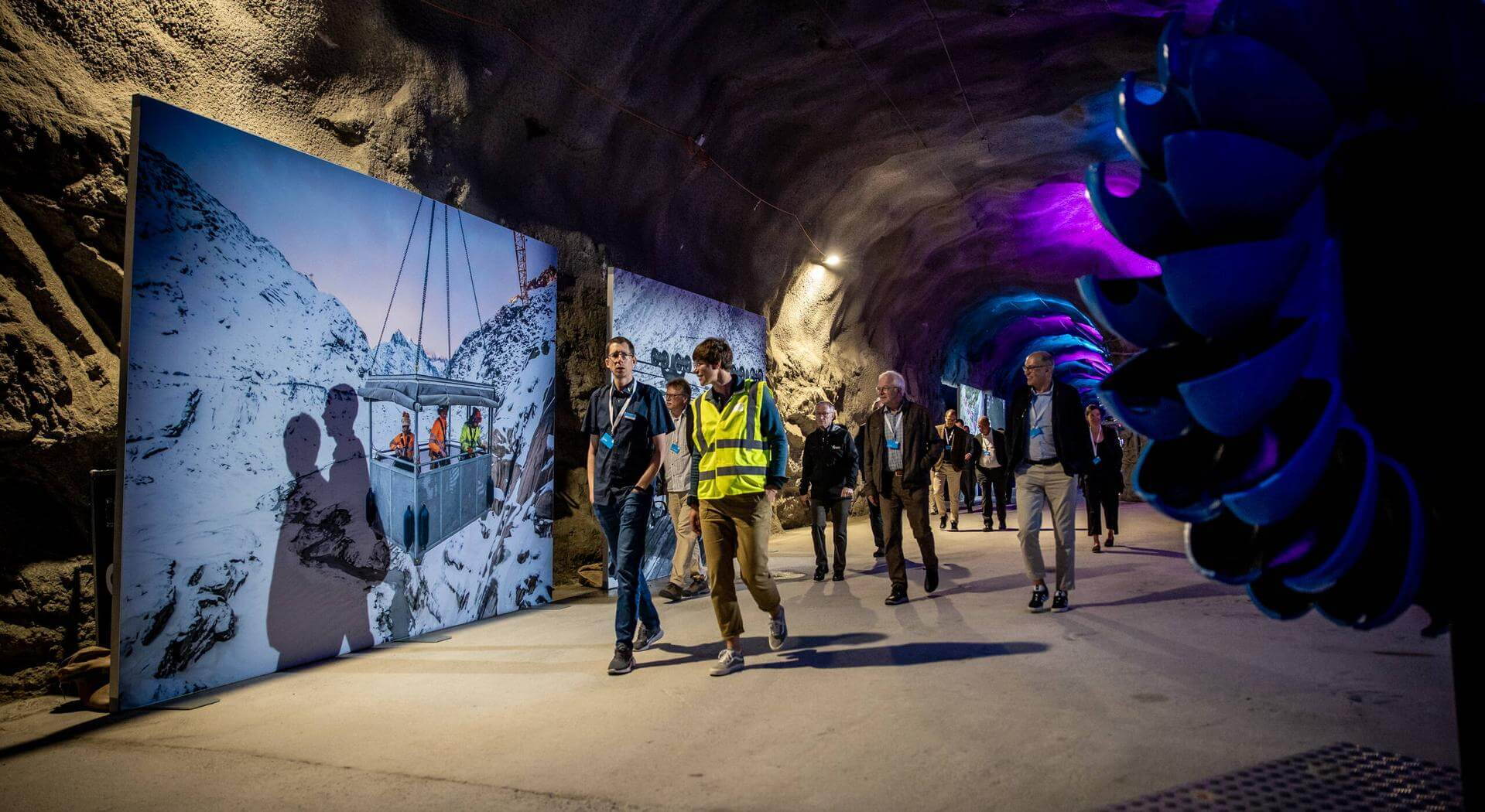 Inszenierte Ausstellung im Stollen der Grimsel: Besucher:innen entdecken historische Bilder und Installationen zur 100-jährigen Geschichte der KWO.