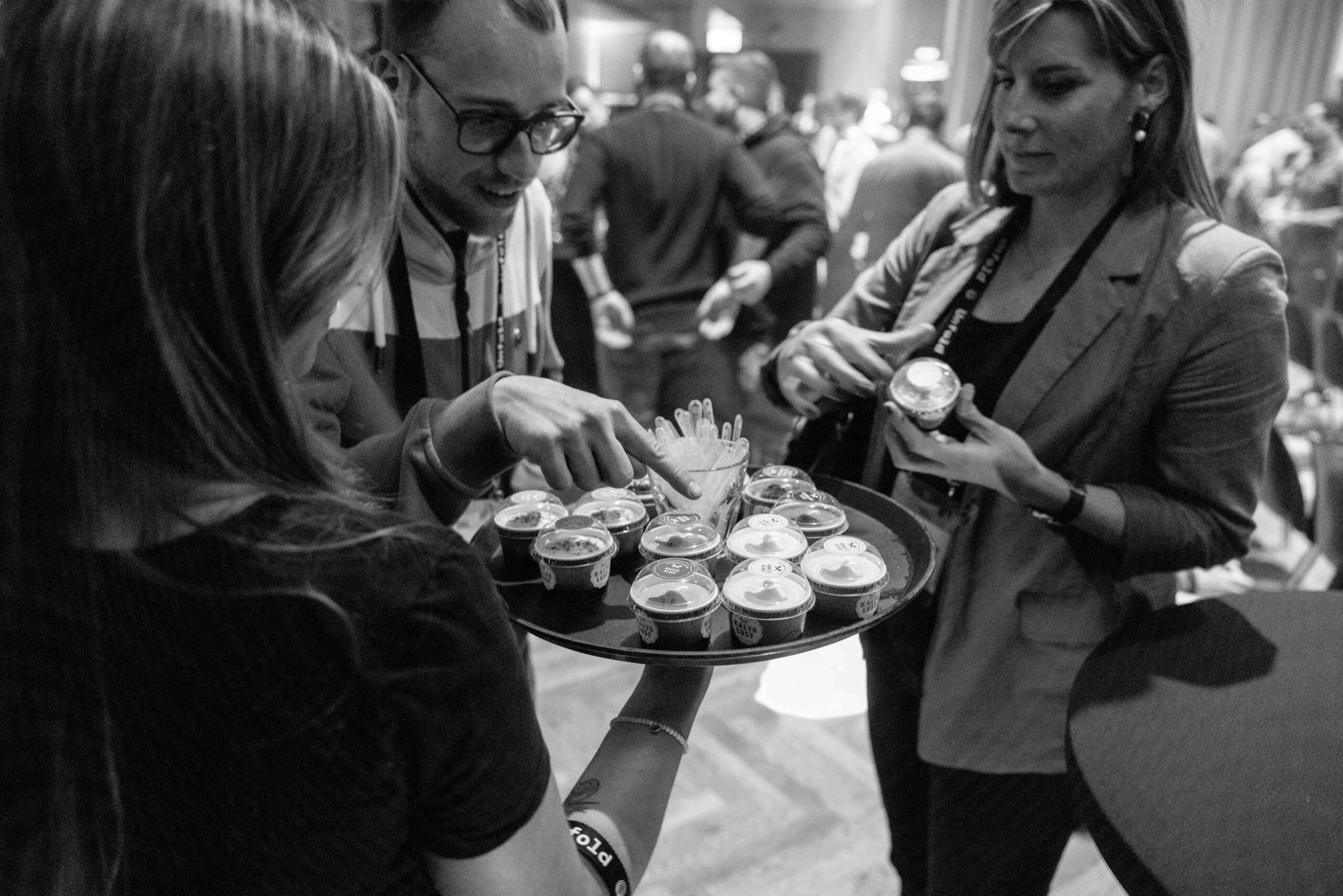 unfold_businessevent_evenjo_ag_bierhuebeli_bern-2.jpg Schwarz-Weiß-Aufnahme von Gästen beim Catering mit Fingerfood – Business-Event. Corporate Event, Eventbühne, Eventdesign, grüne Lichtstimmung, Dschungel Deko, Business Event, live kommunikation, Eventagentur bern, eventplanung, firmenevents, teamevents bern, jubiläumsfeier, networking anlass, mitarbeiter:innenanlass, Technik, Public Events, Sport und Entertainment Events, markenerlebnis, Brand Experience